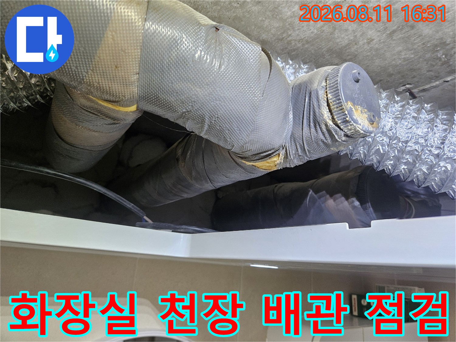 은색 단열재로 감싸진 화장실 천장 하부 배관의 연결 부위 상세 모습