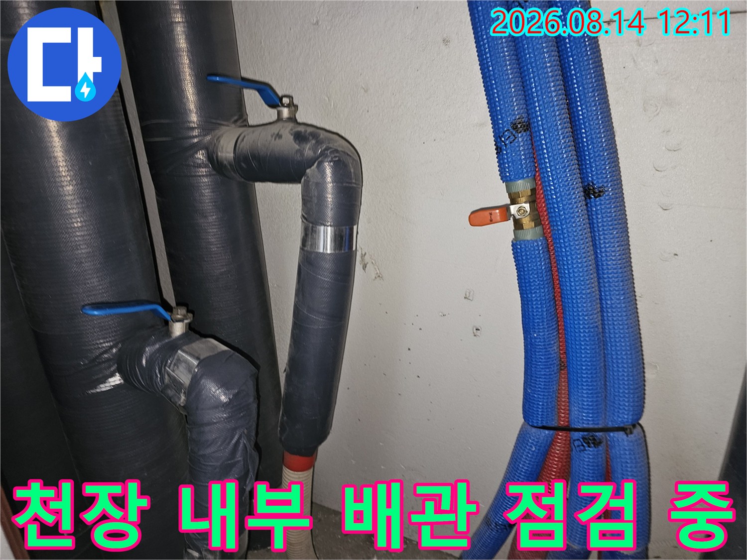 보온재로 감싸진 검은색 배관과 파란색 주름관의 연결 부위