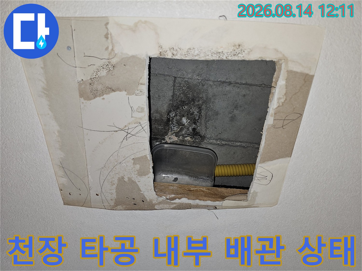 천장 타공을 통해 드러난 콘크리트 슬라브와 노란색 배관 연결부