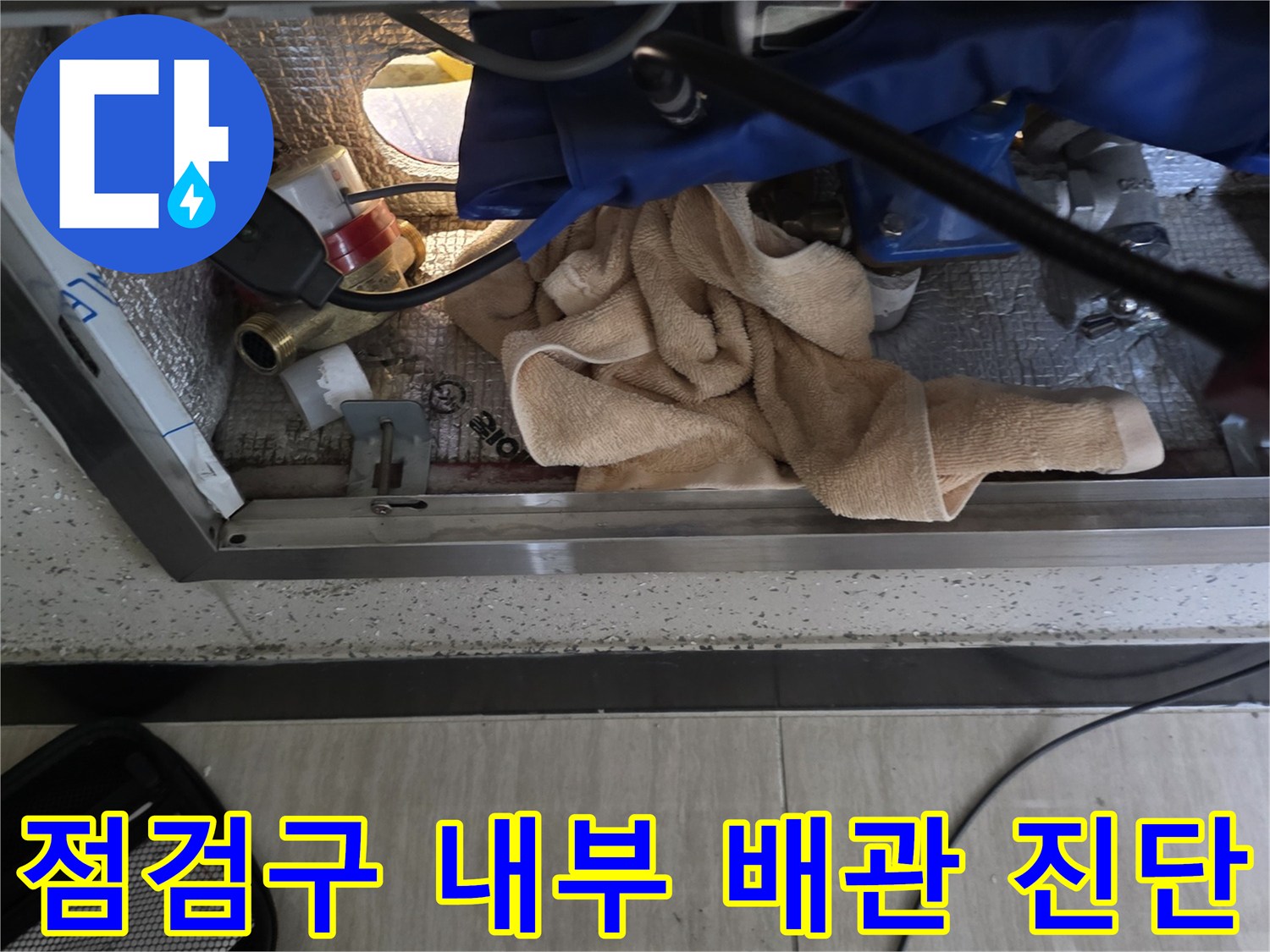좁은 점검구 내부-배관 상태를 확인하기 위해 내시경과 압력계를 사용하는 모습