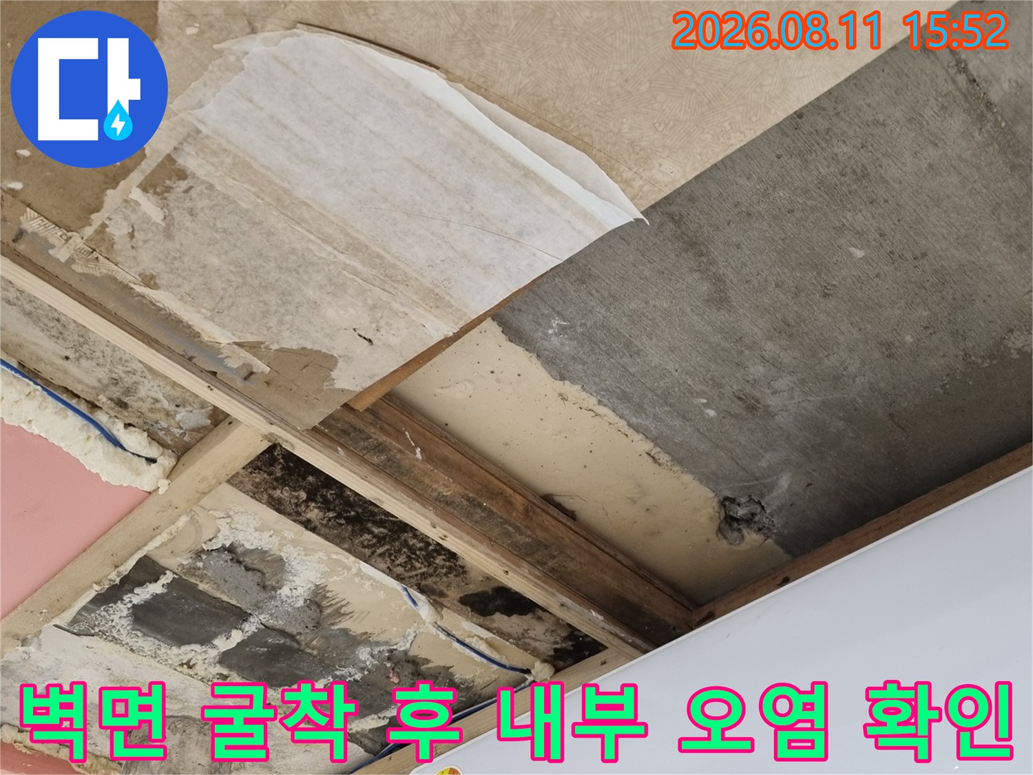 에어컨 실내기 하단 벽을 일부 제거하여 드러난 습한 단열재와 벽면 모습