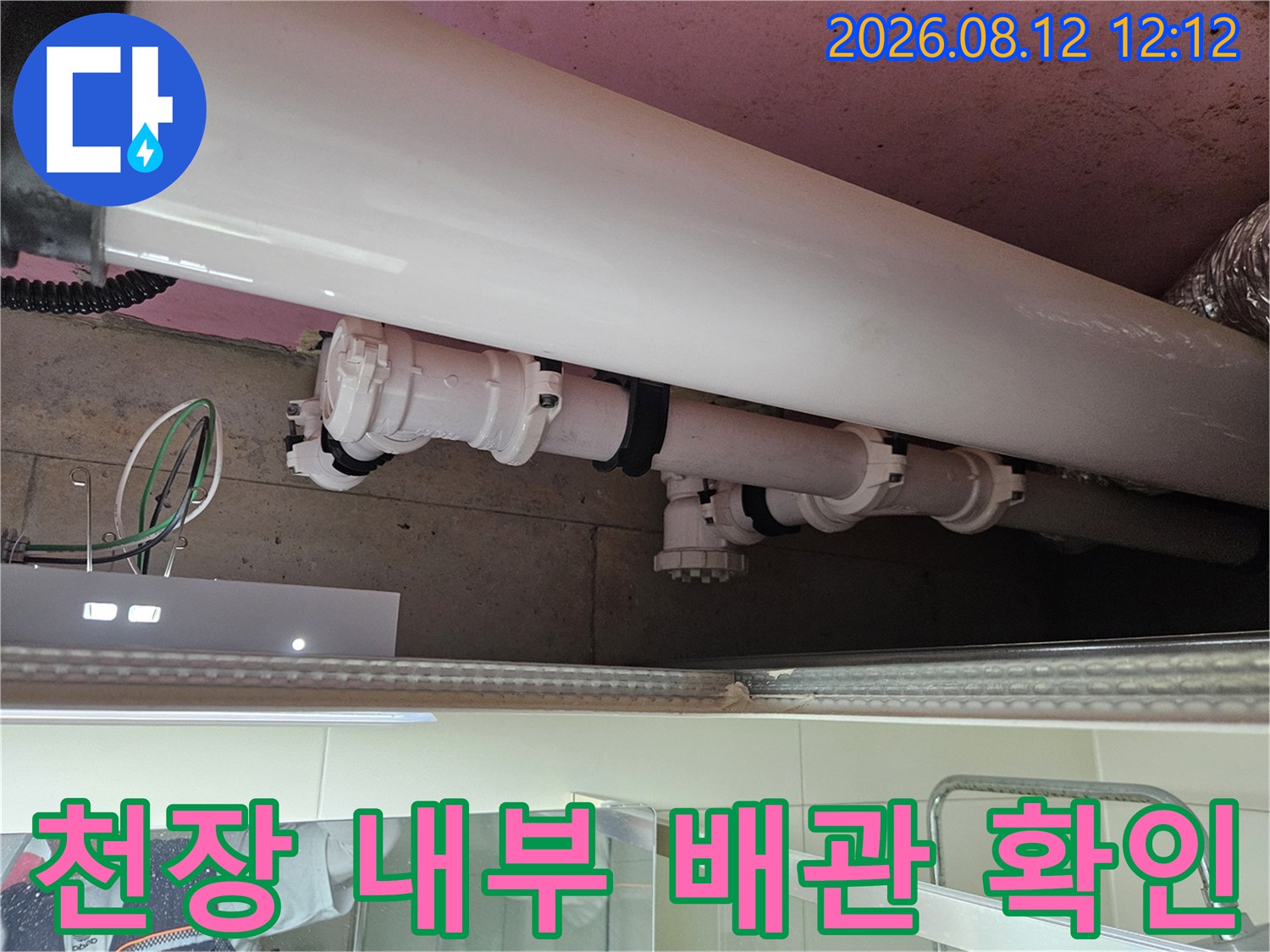 천장 안쪽 하얀색 배관과 연결 부위의 누수 흔적을 촬영한 사진입니다.