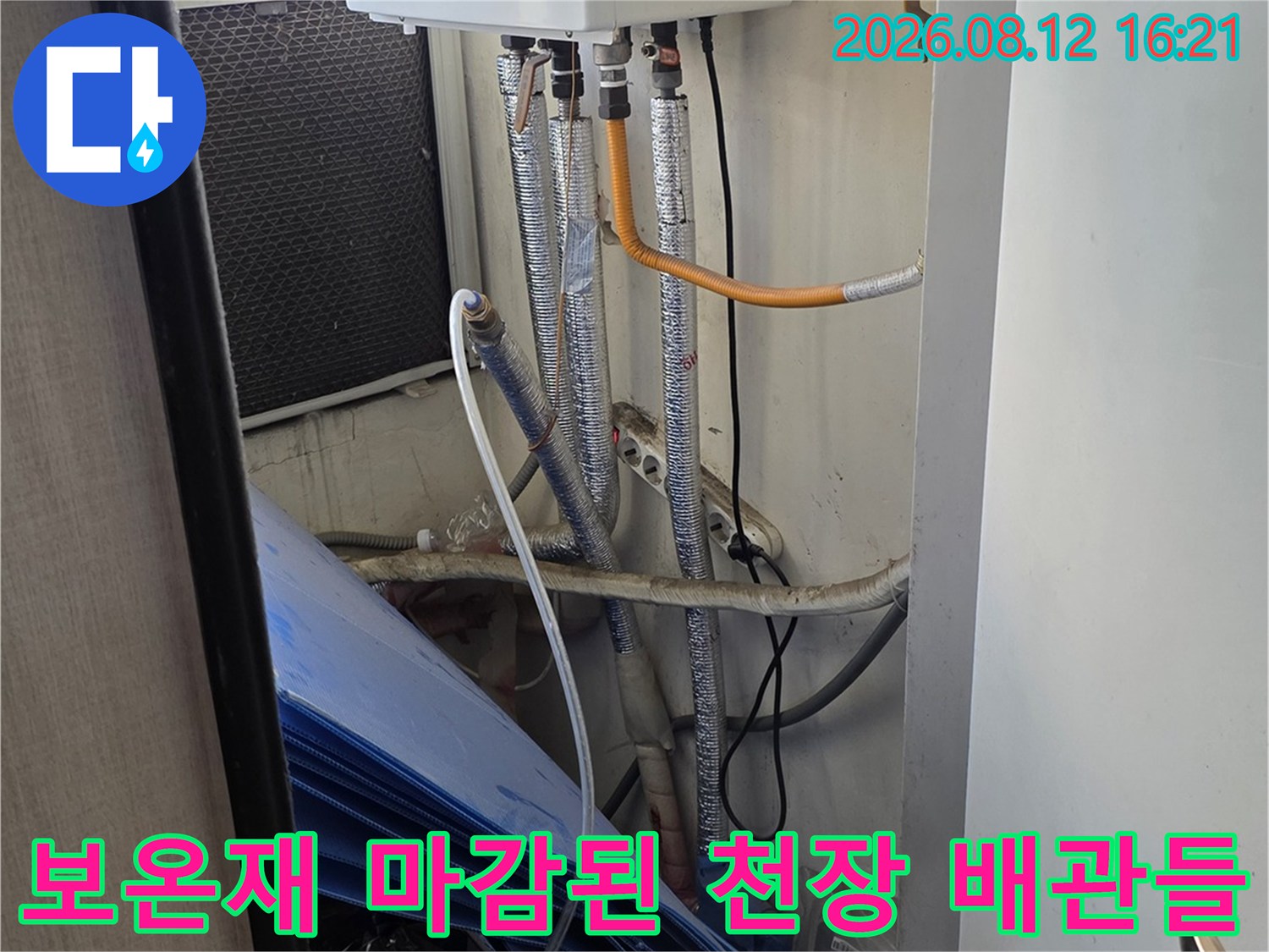 은색 단열재로 꼼꼼하게 감싸진 천장 내부 배관과 흰색 보일러 장비 모습