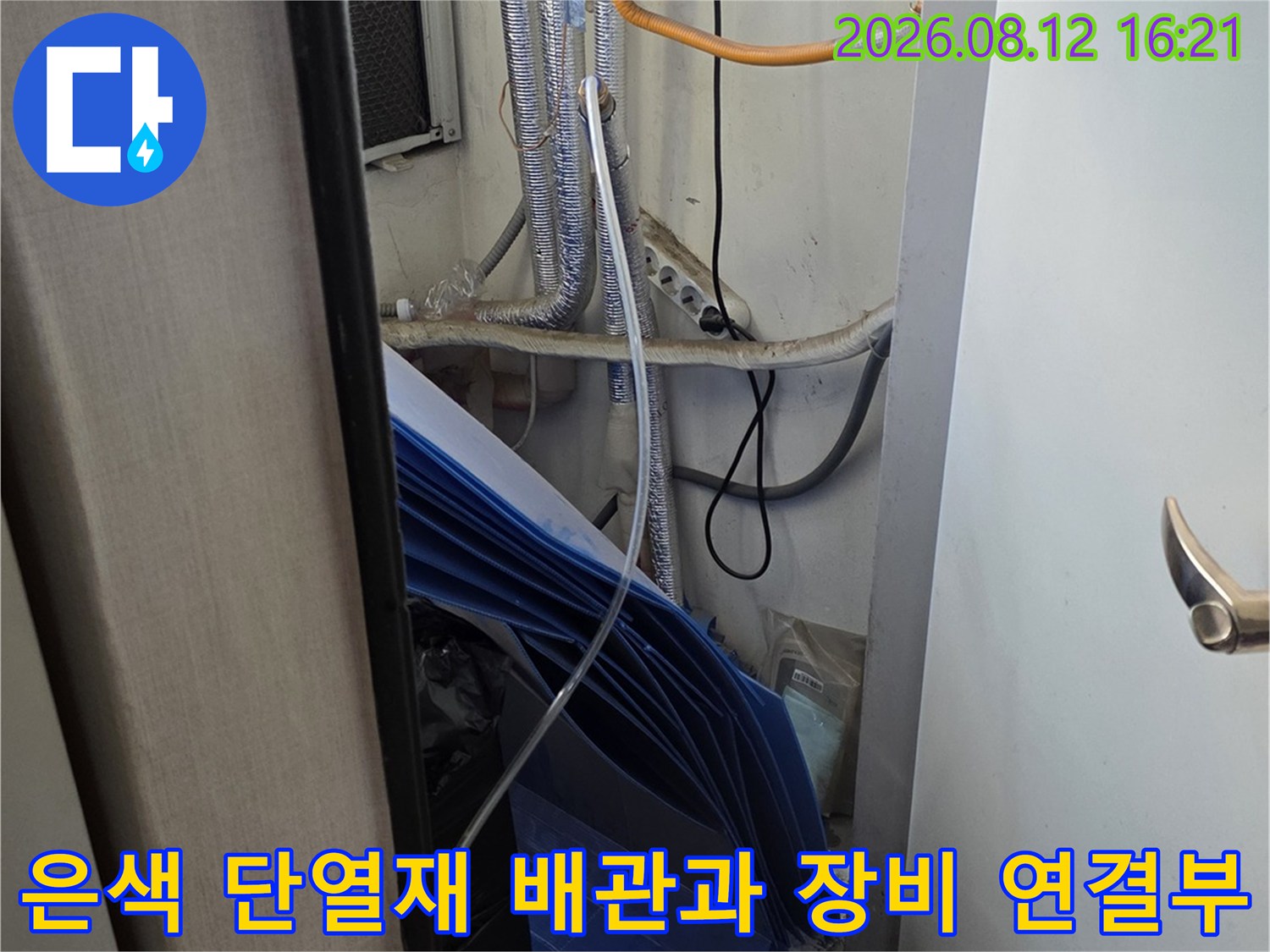 흰색 가전 장비 옆으로 배치된 은색 보온재 처리된 배관들의 모습