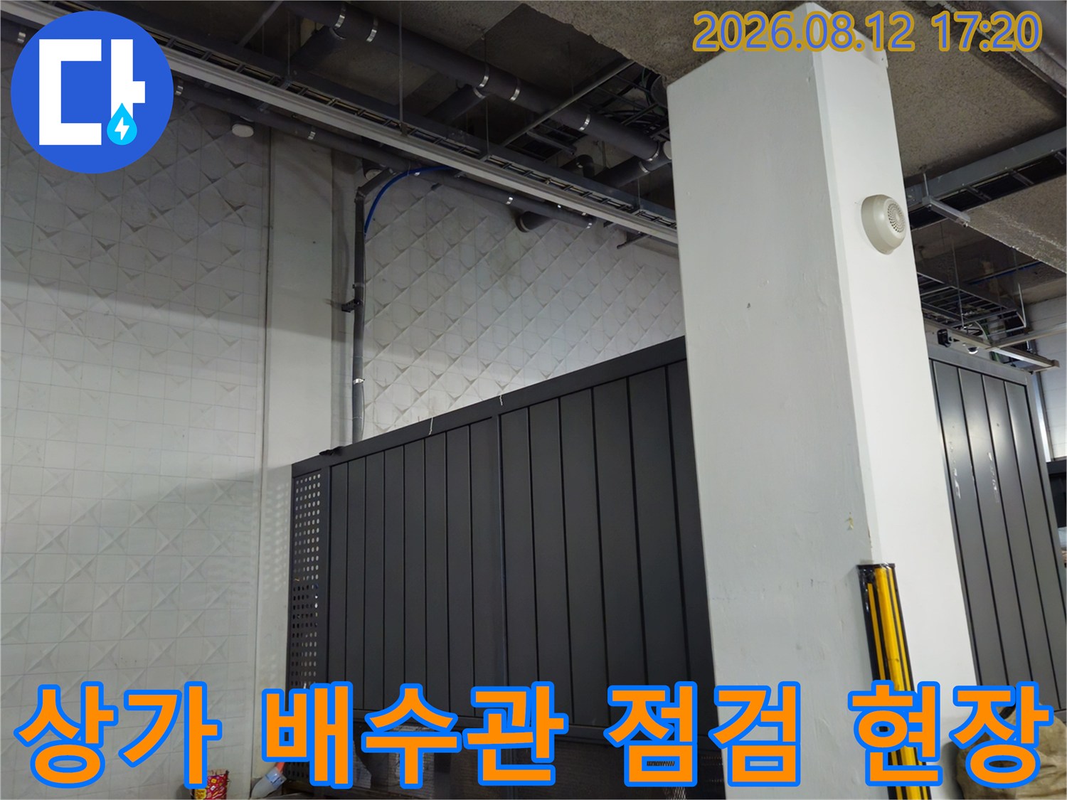 상가 지하 시설의 배수관 및 벽면 마감재 상태를 촬영한 사진입니다.