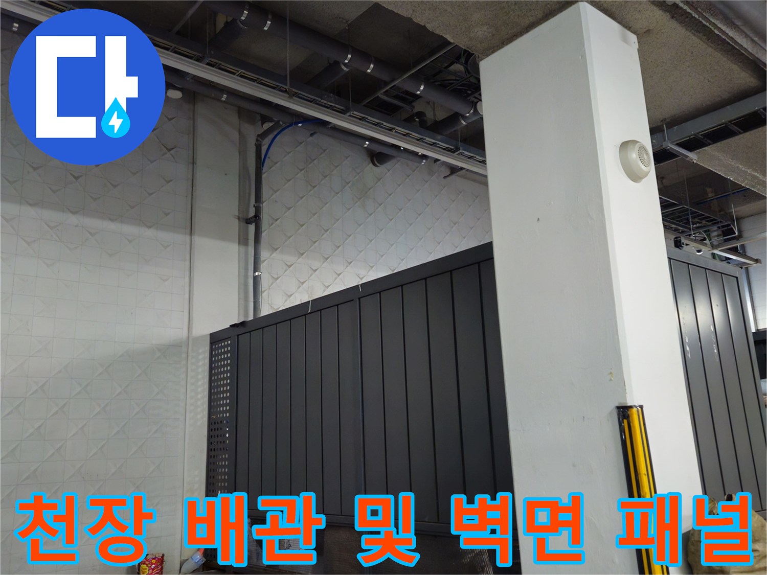 지하 주차장 구조물-천장 배관과 흰색 벽면 패널