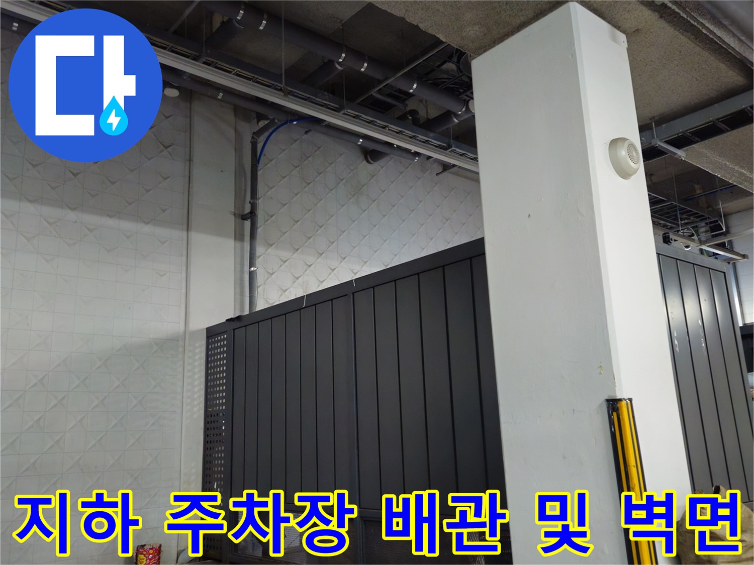 지하 주차장 내부-노출된 천장 배관과 벽면 패널
