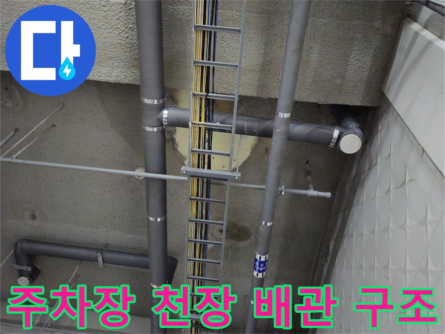 지하 주차장 상부에 설치된 회색 PVC 관과 전선 트레이 시설물