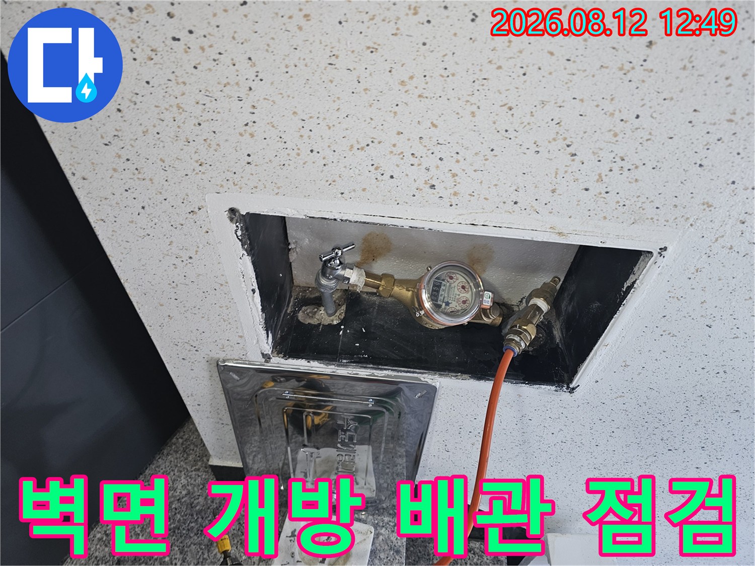 벽면을 절개하여 노출된 수도 계량기와 배관 연결 상태를 촬영하였습니다.