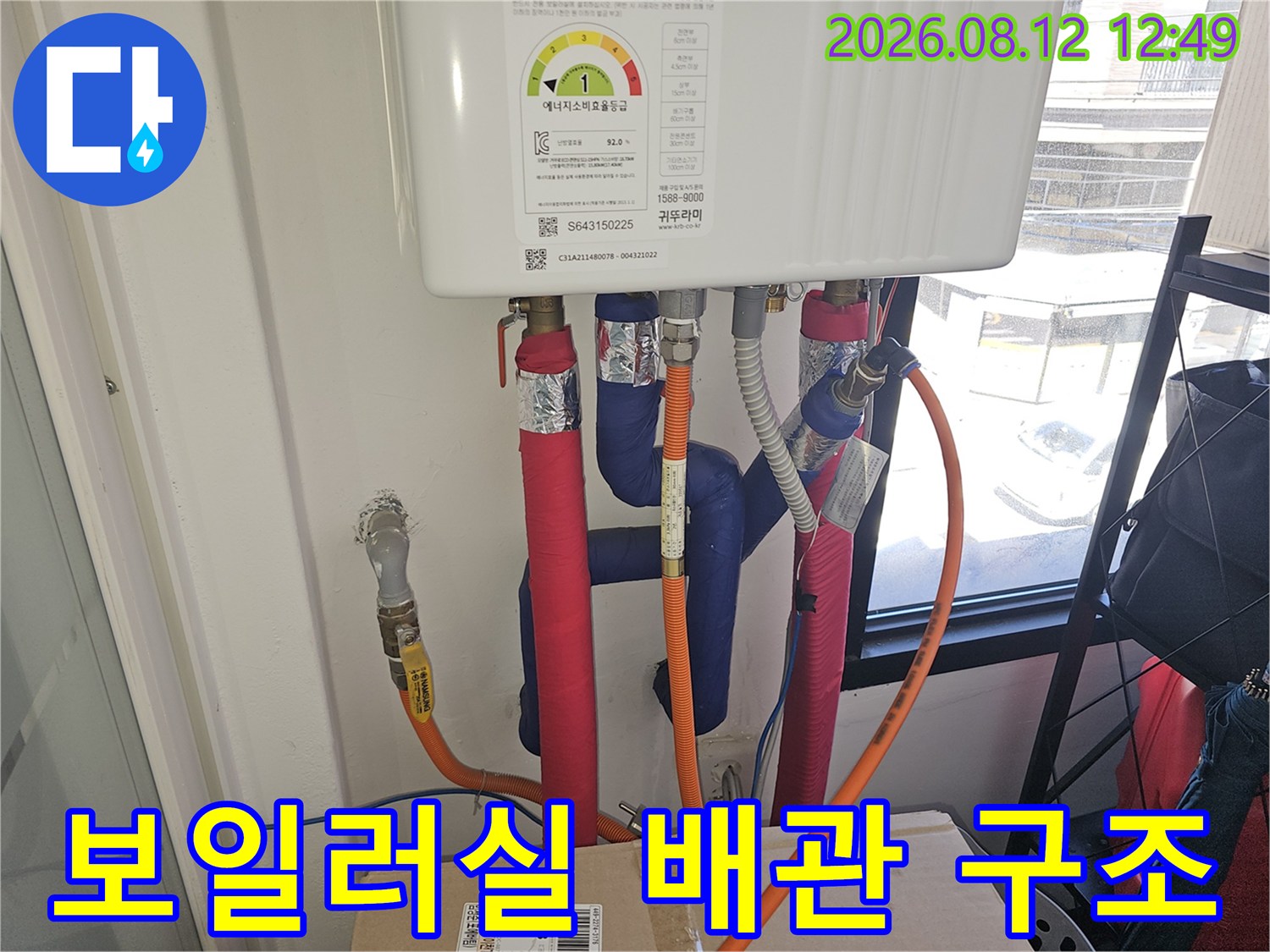 보온재로 덮인 파란색과 분홍색 배관의 보일러 연결 부위