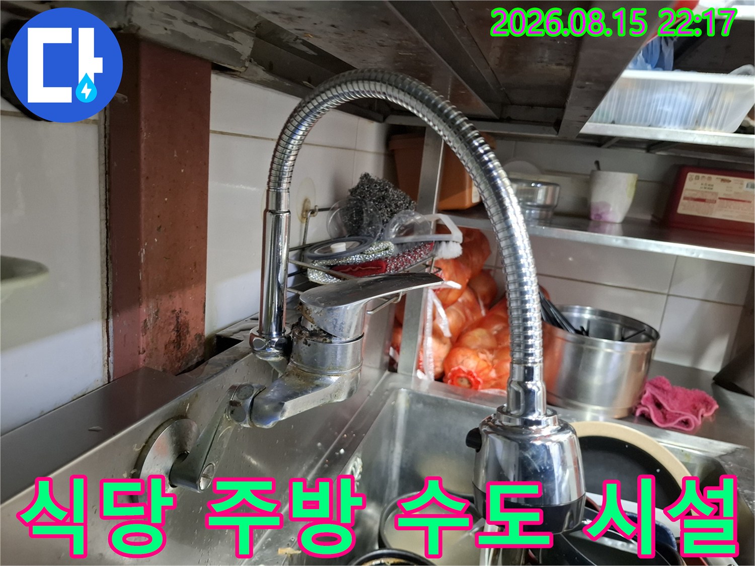스테인리스 싱크대와 유연한 수전이 설치된 식당 주방의 모습입니다.