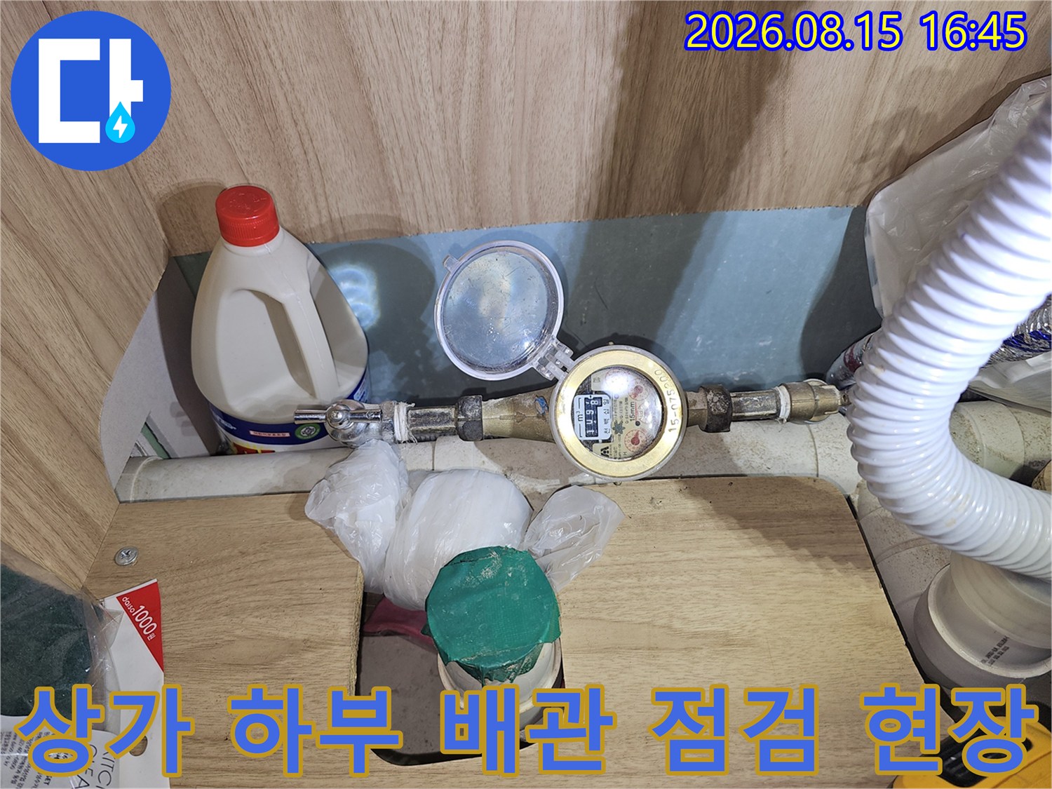 복잡하게 연결된 상가 내부의 수도 계량기와 급수 배관을 조사하는 장면입니다.