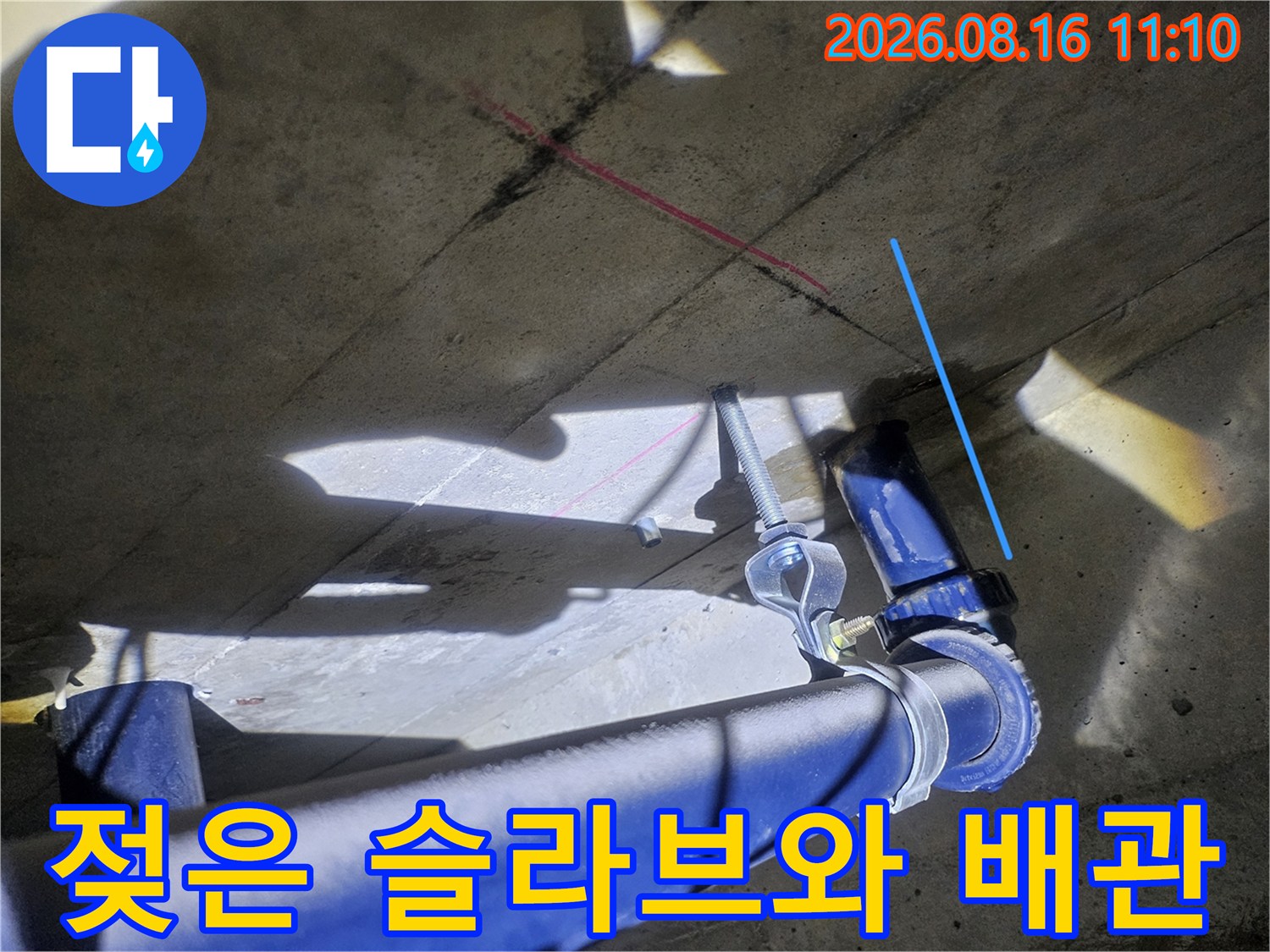 습기가 찬 콘크리트 슬라브와 파란색 배수 배관의 근접 촬영