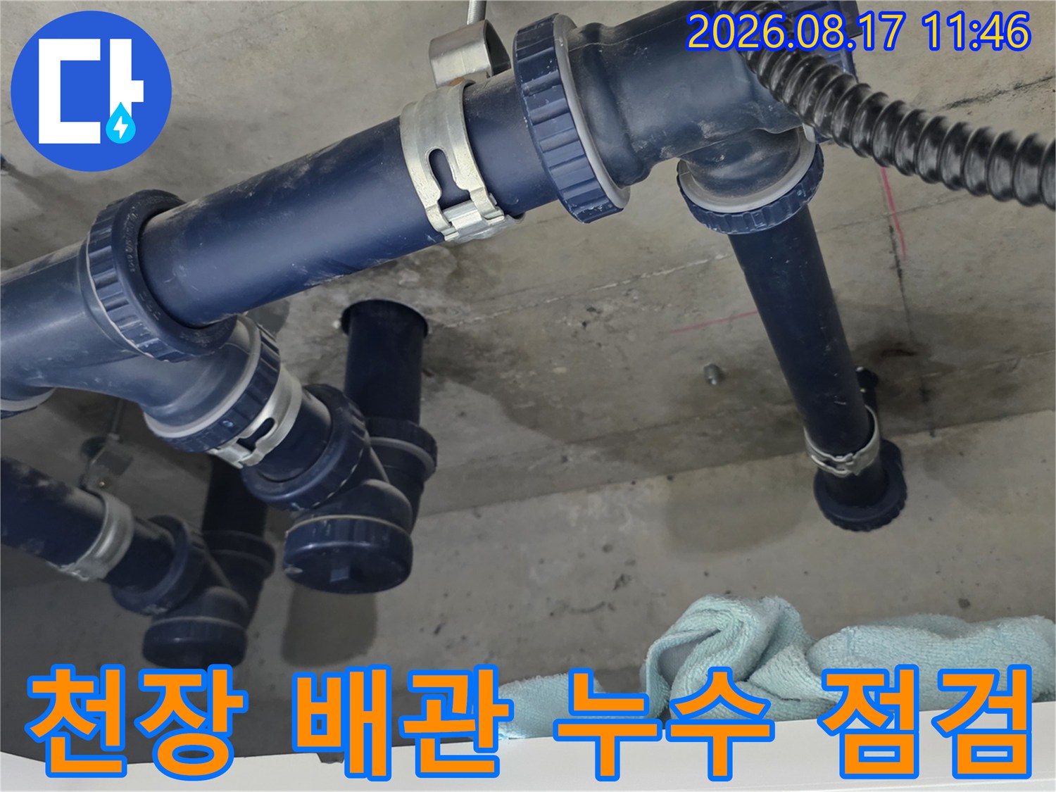 하늘색 배수 배관 주변의 젖은 천장 슬라브를 촬영한 사진입니다.