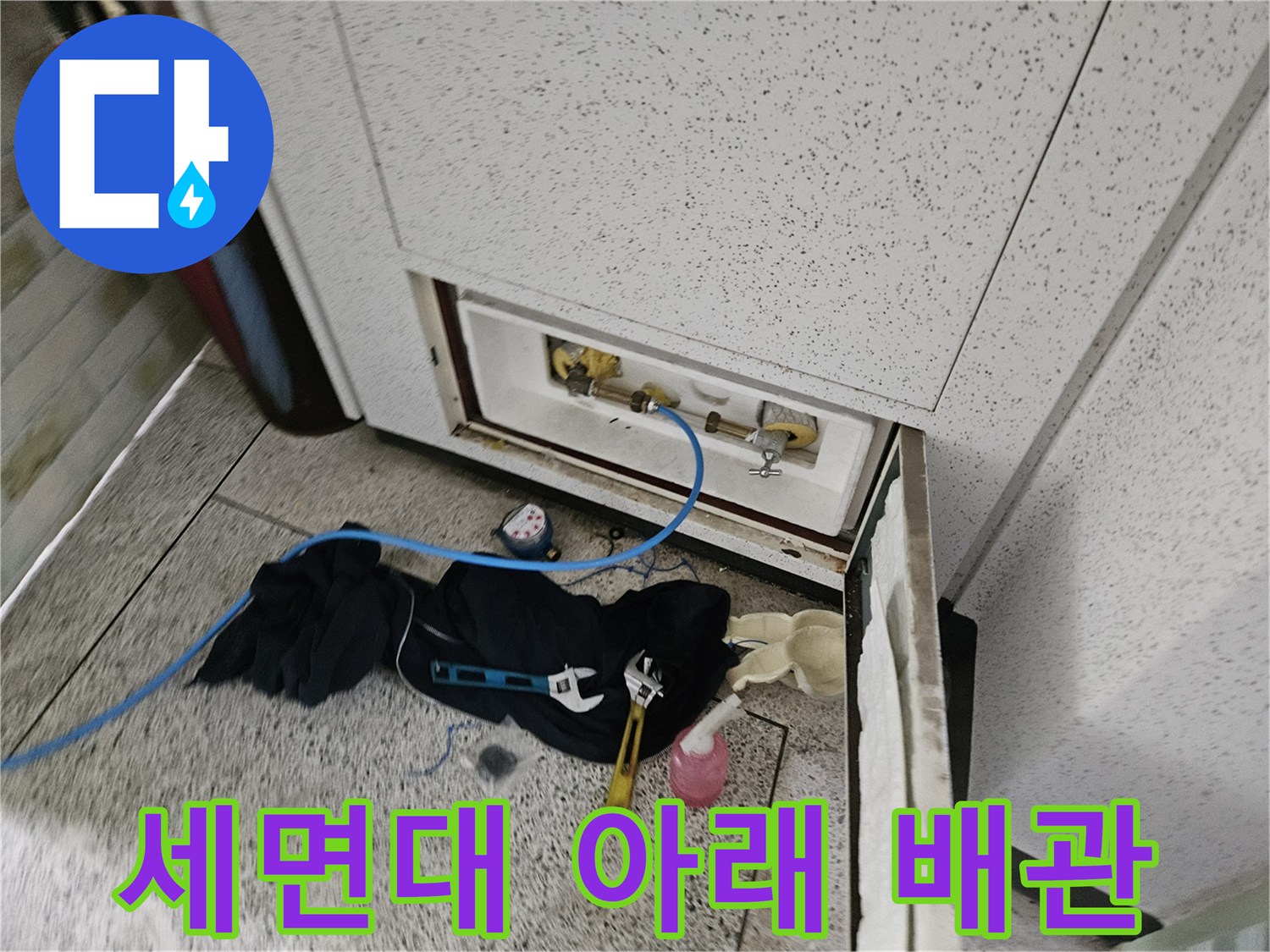 세면대 하단 앵글밸브와 연결된 직수 배관을 점검하는 장면입니다.