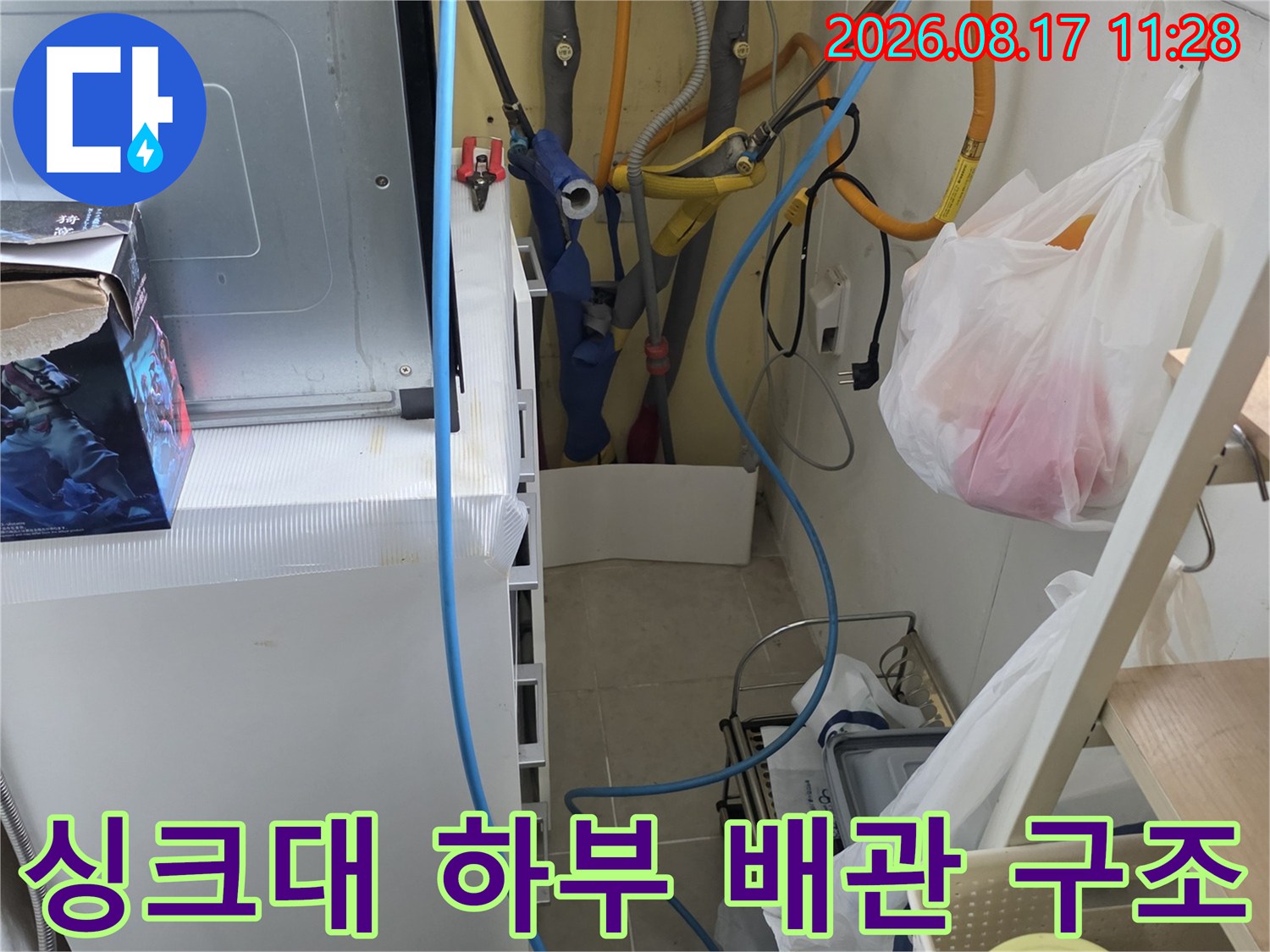 복잡하게 연결된 싱크대 하부의 수도 배관과 정수기 호스 점검 장면입니다.