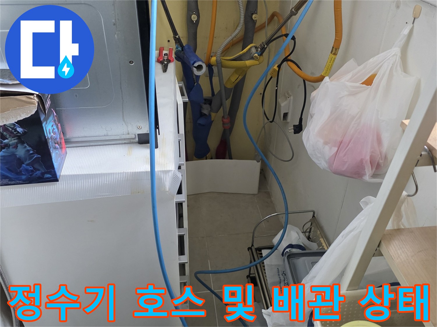 싱크대 하부의 노란색과 파란색 수도 배관이 복잡하게 연결된 현장 모습입니다.