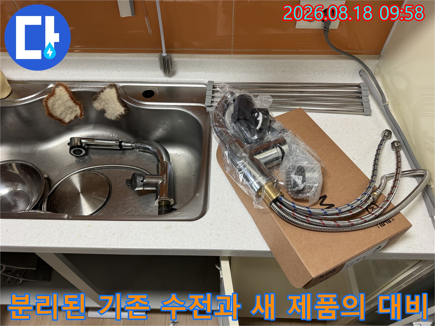 낡은 싱크대 배관 부속과 깨끗한 새 수전 호스가 나란히 보입니다.