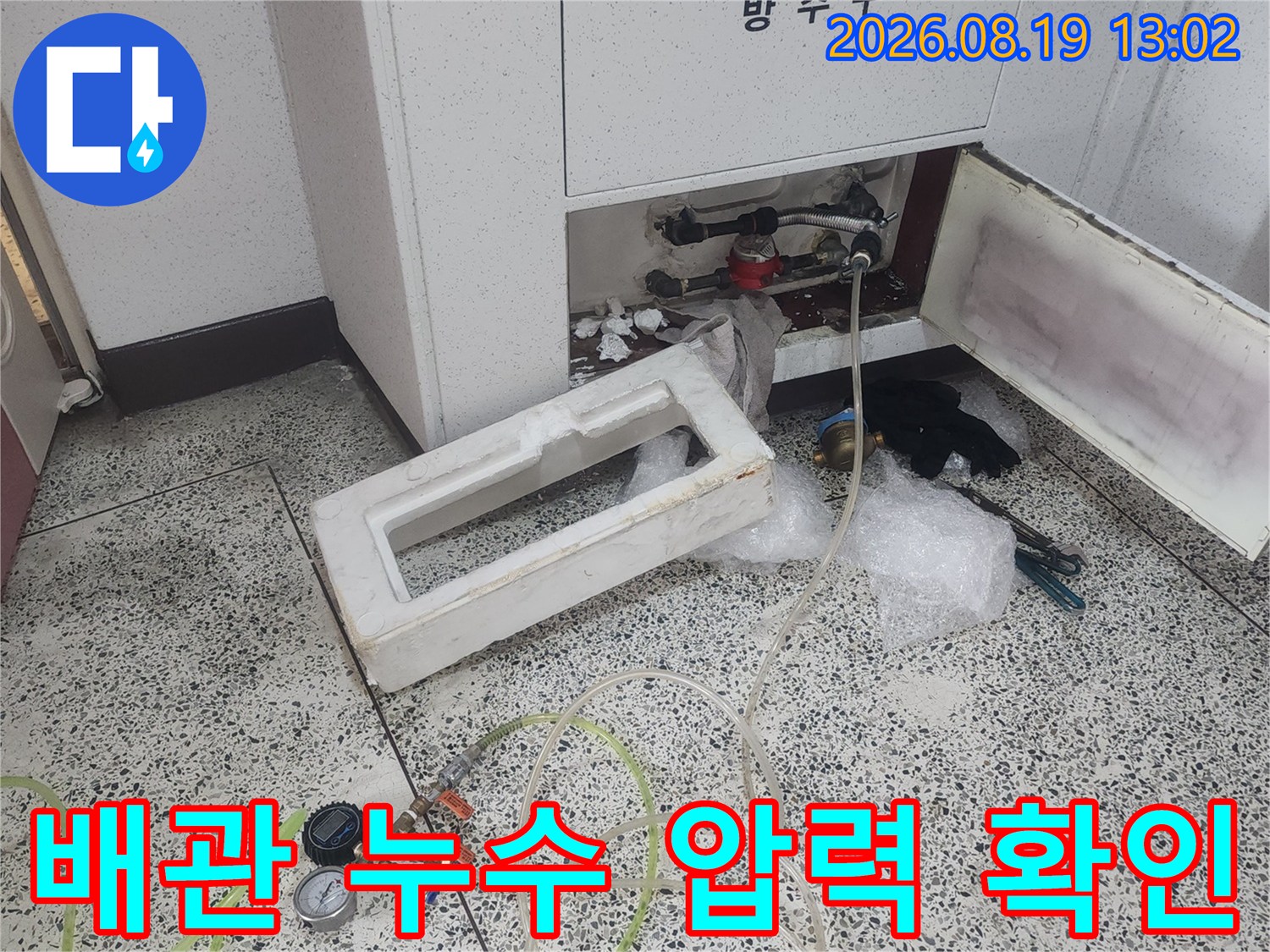 싱크대 하부 배관에 설치된 압력계와 연결 호스의 모습입니다.