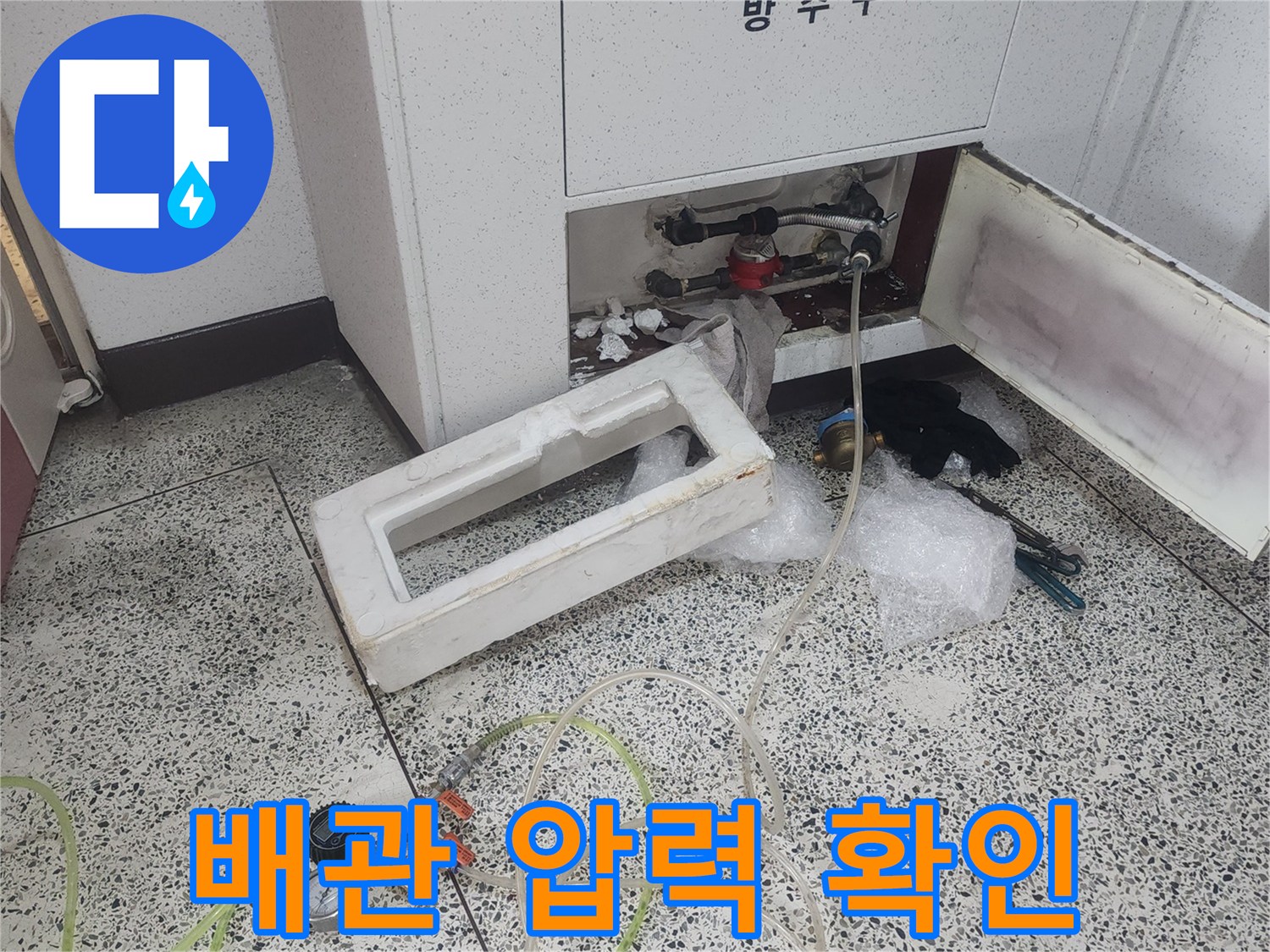 하부장 내부 배관에 연결된 게이지와 테스트 호스