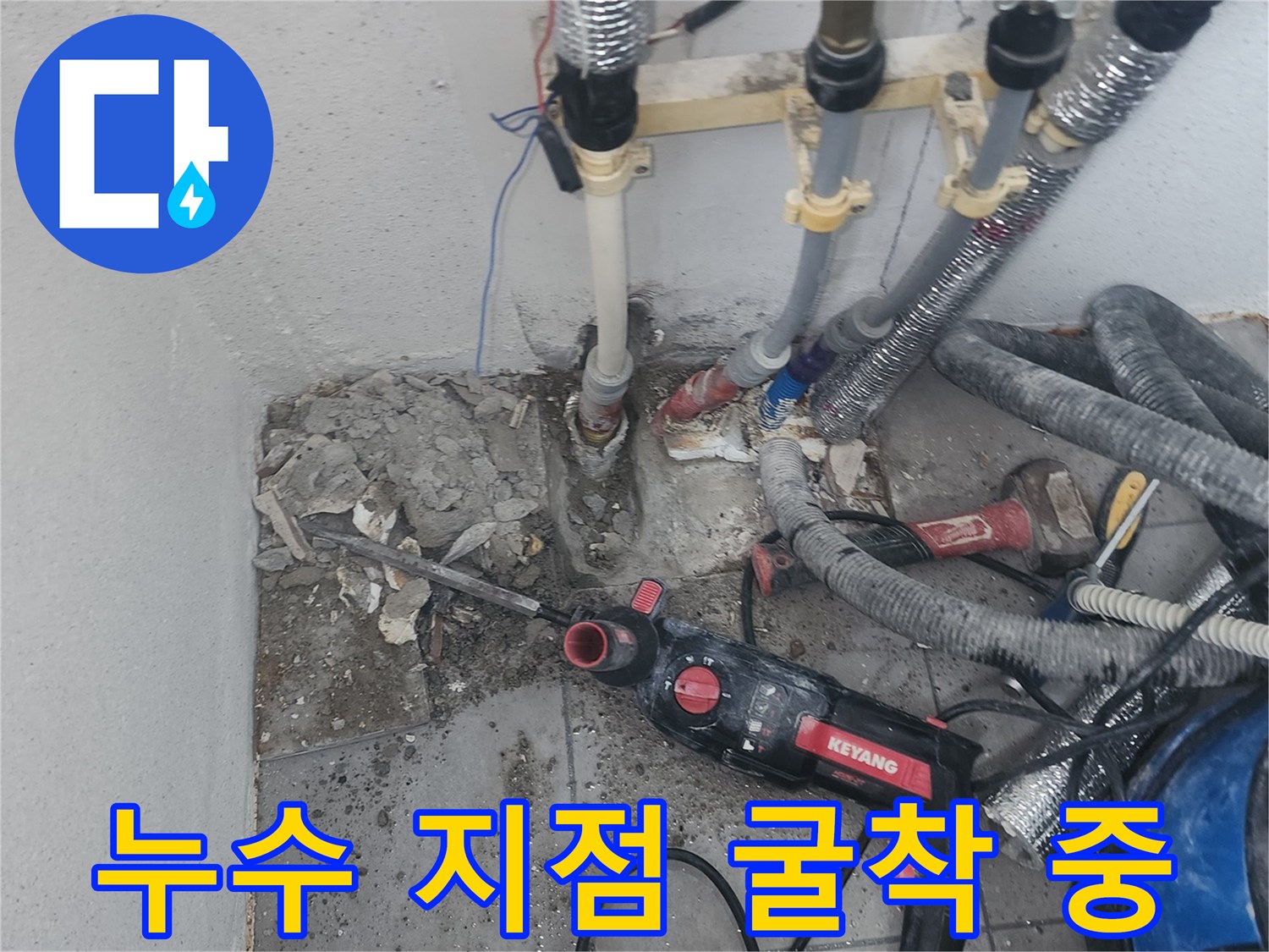 파쇄 장비를 사용하여 바닥을 파내어 배관을 노출시키는 장면