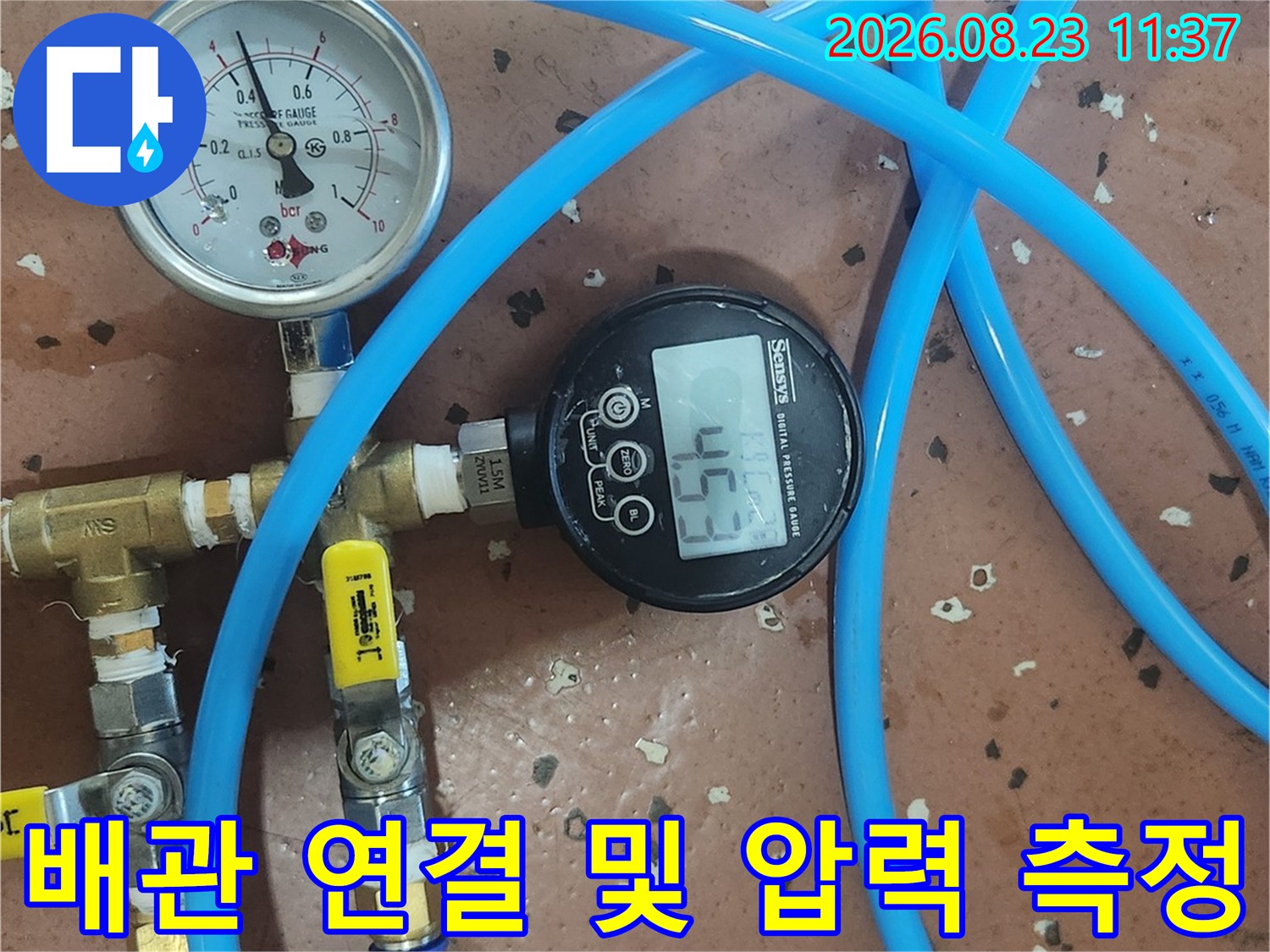 파란색 호스가 연결된 배관 검사용 게이지 장치