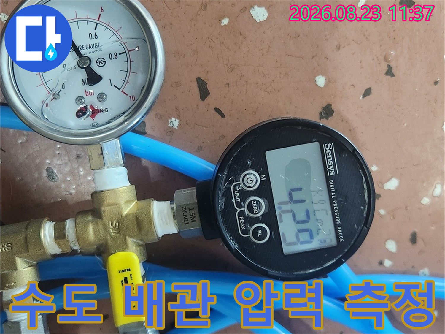 파란색 호스와 연결된 수도 배관의 공압 측정 장비 모습