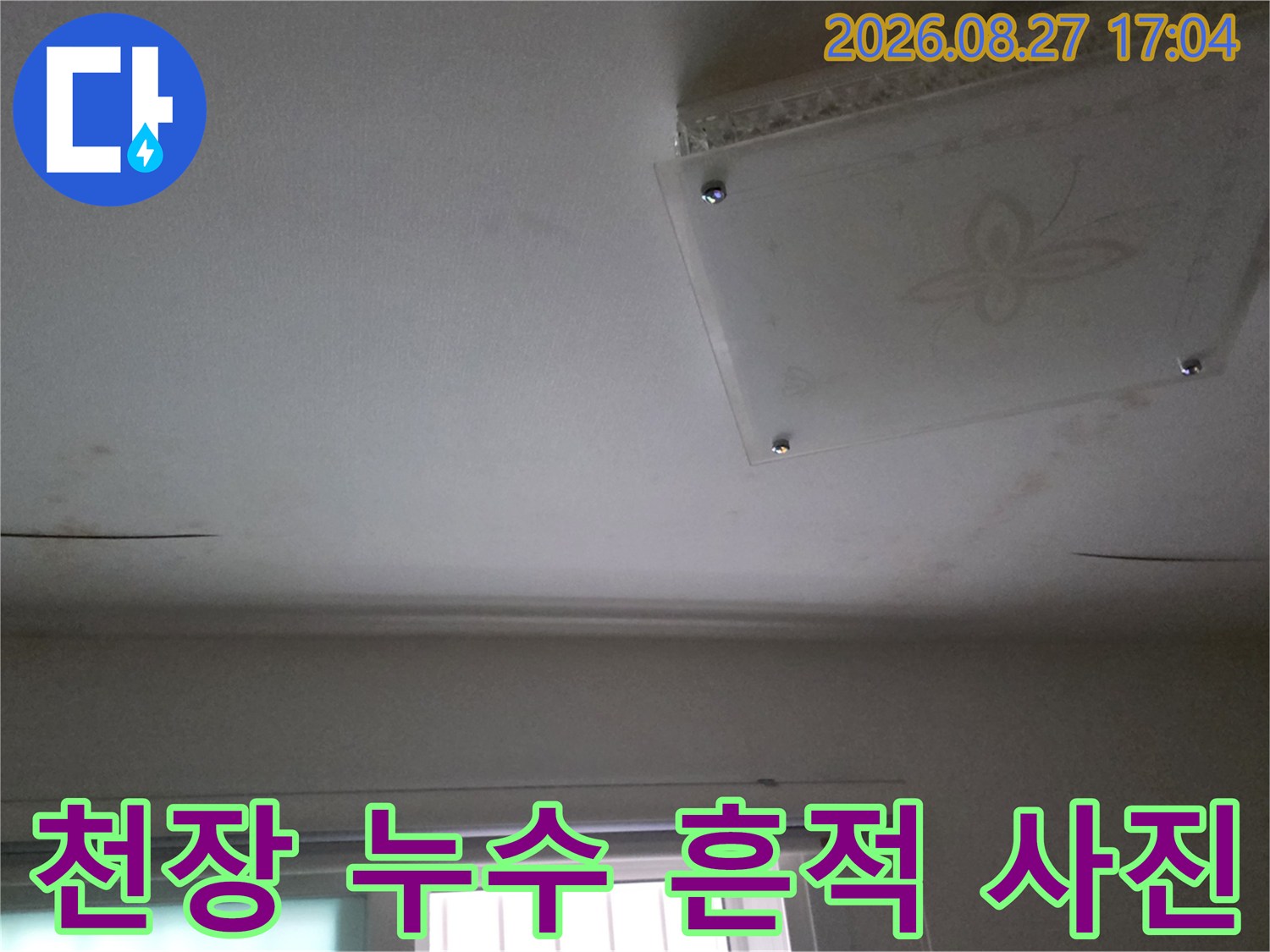 천장 가장자리 부분의 어두운 누수 얼룩 현상