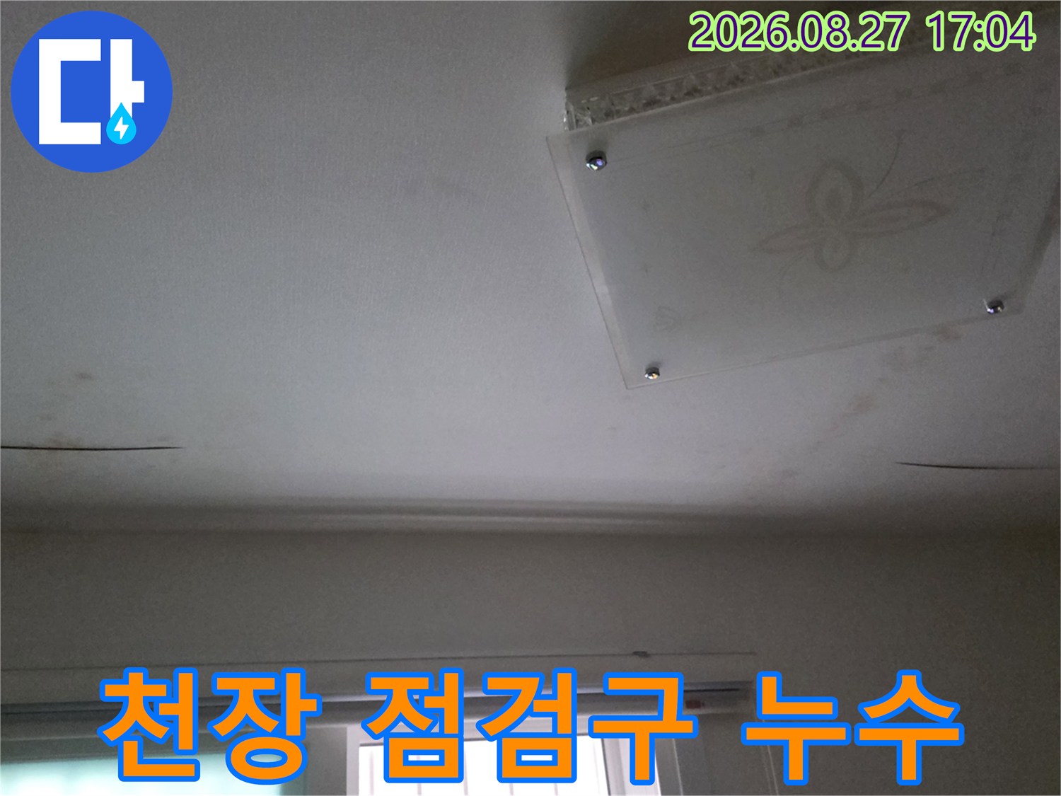 천장 점검구 주변에 발생한 어두운 물자국과 습기 침투 현상입니다.