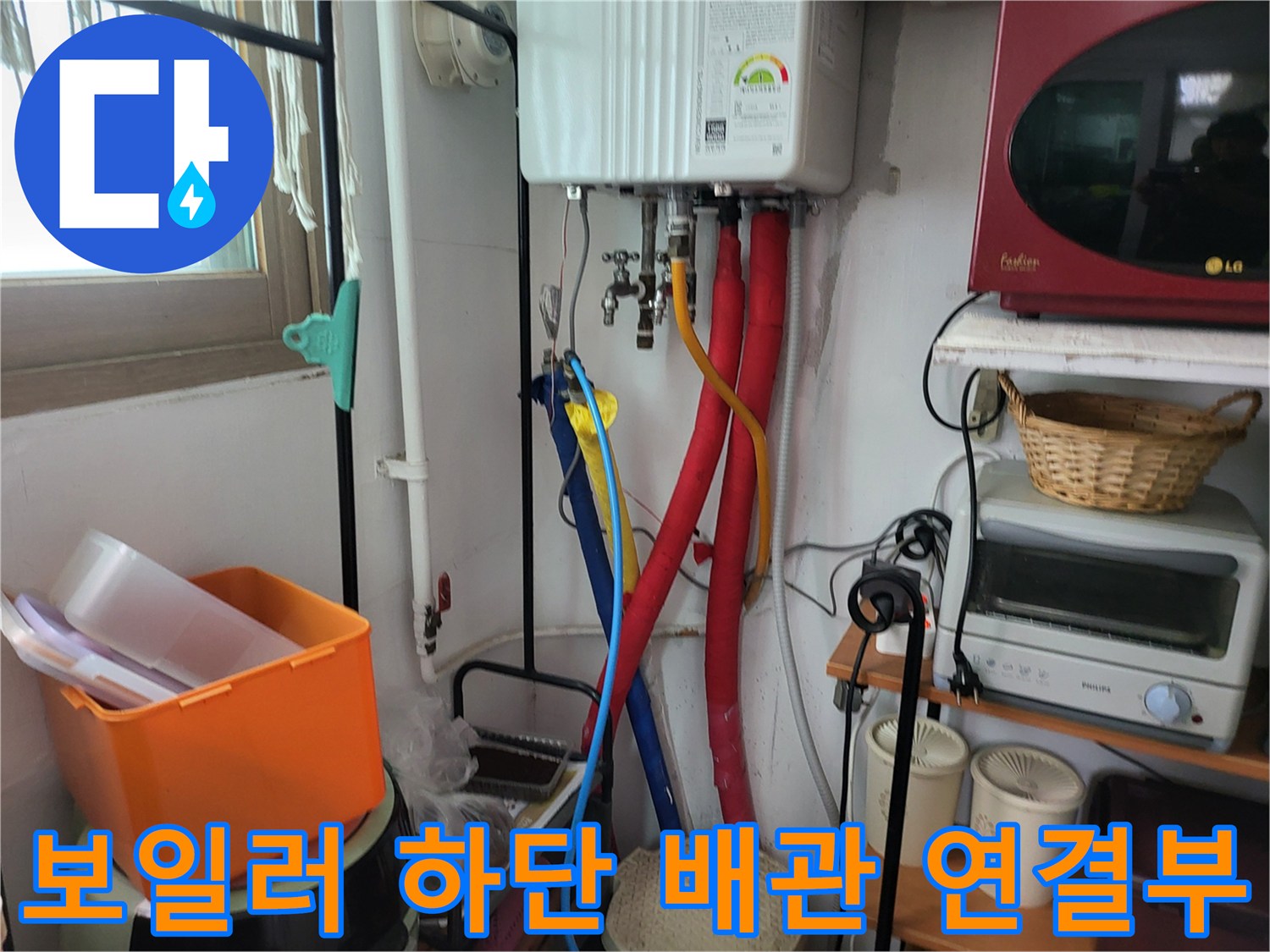보일러 아래쪽으로 이어지는 유연한 배관과 밸브 부위 사진