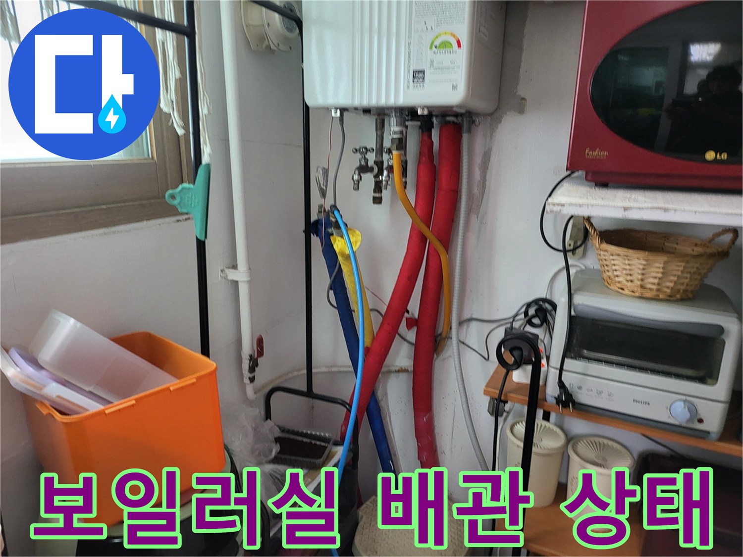 보일러 하단에 연결된 다양한 색상의 급수 및 온수 배관 모습