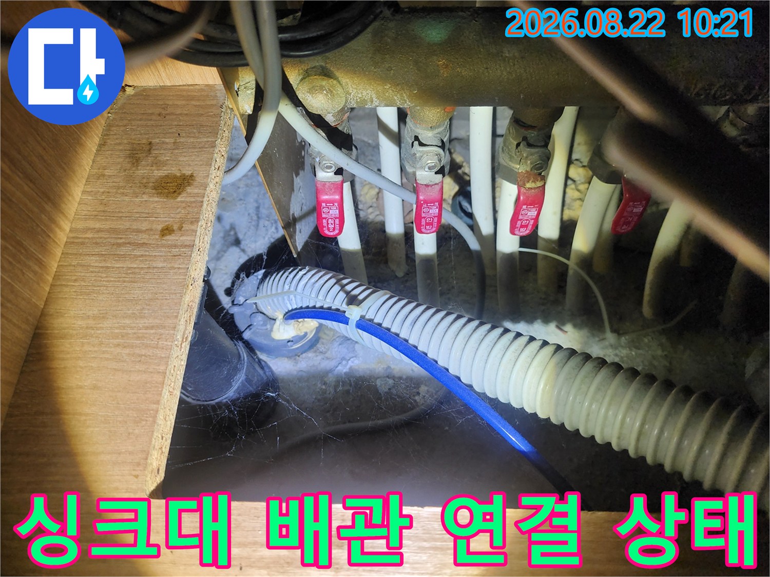 복잡하게 얽힌 싱크대 하단 급수 밸브와 배수 호스