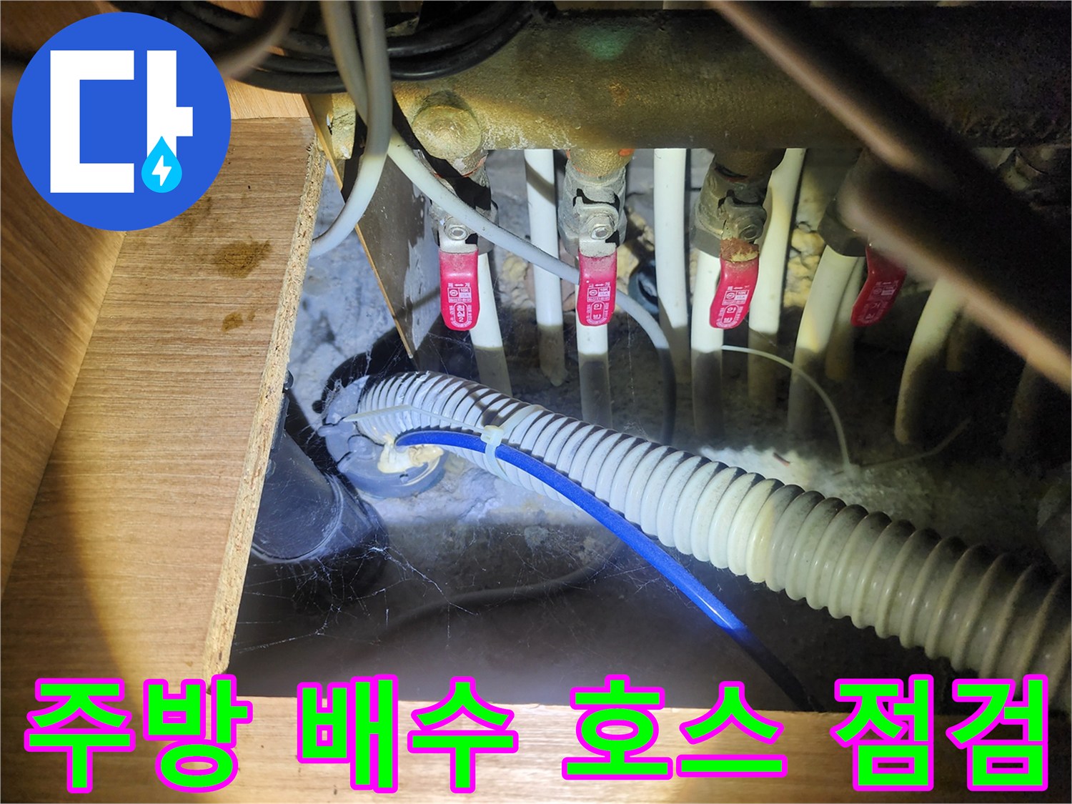 젖어 있는 싱크대 하부의 수도 밸브와 배수 관로