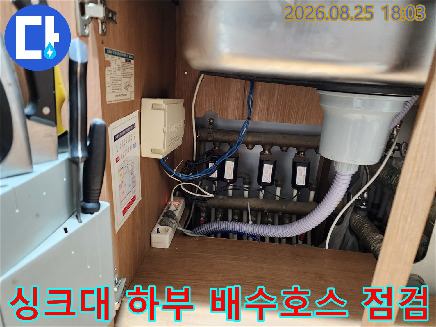 싱크대 배수구와 연결된 흰색 주름관 및 다수의 배관 연결 부위 근접 촬영