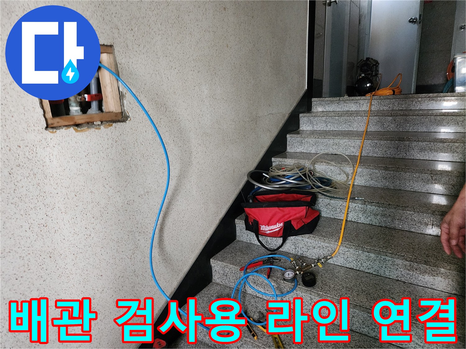 벽면 타공 부위에 설치된 배관 점검용 호스