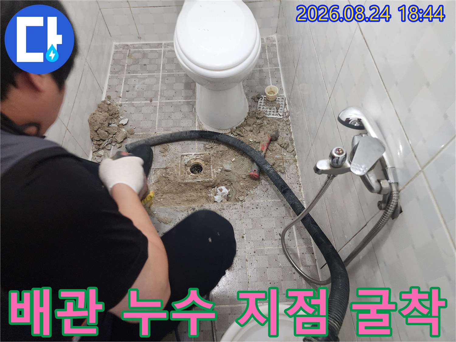 변기 근처 타일을 제거하고 배관의 손상 부위를 노출시킨 모습입니다.