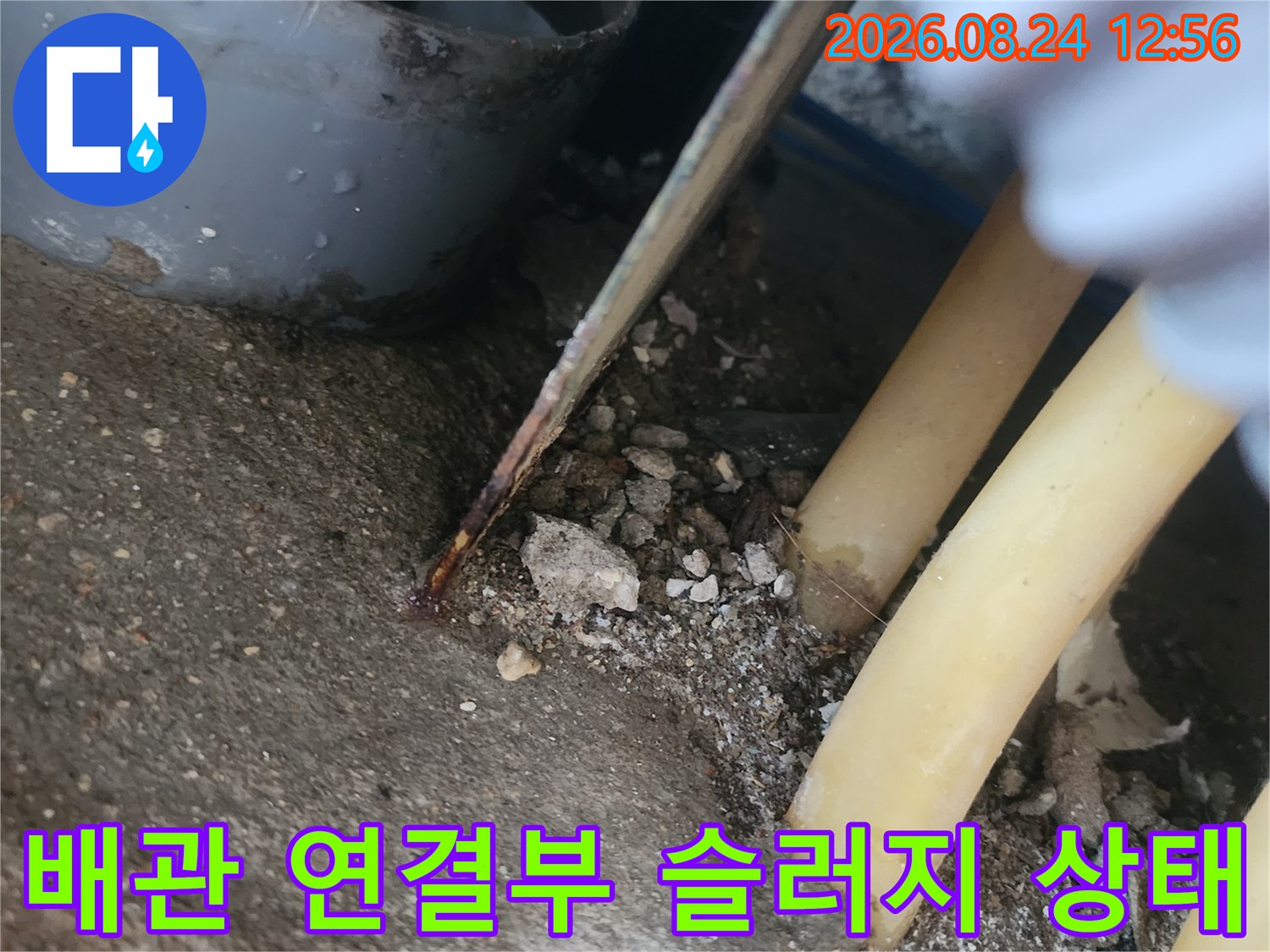 노란 배관과 주변의 이물질이 섞인 현장 모습입니다.