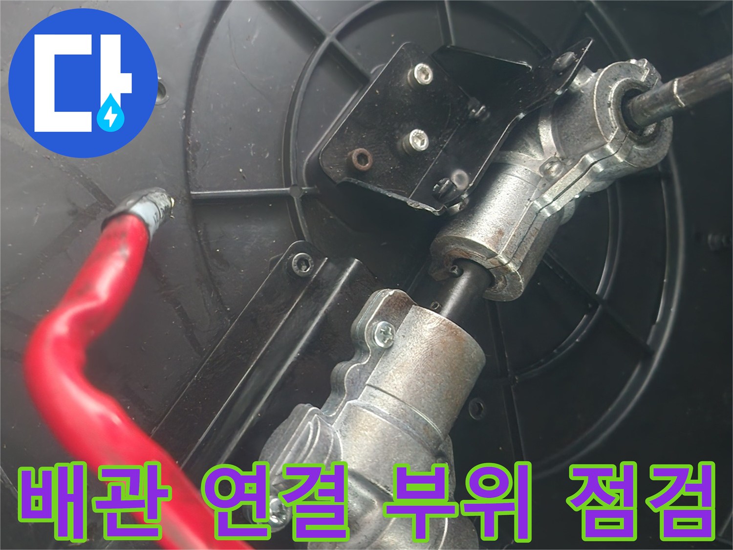복잡한 구조의 싱크대 하단 배관 및 붉은색 호스 이미지