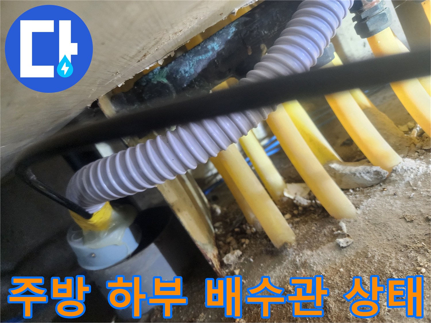 싱크대-하부-노란색-배수관과-보라색-자바라-호스-연결-모습