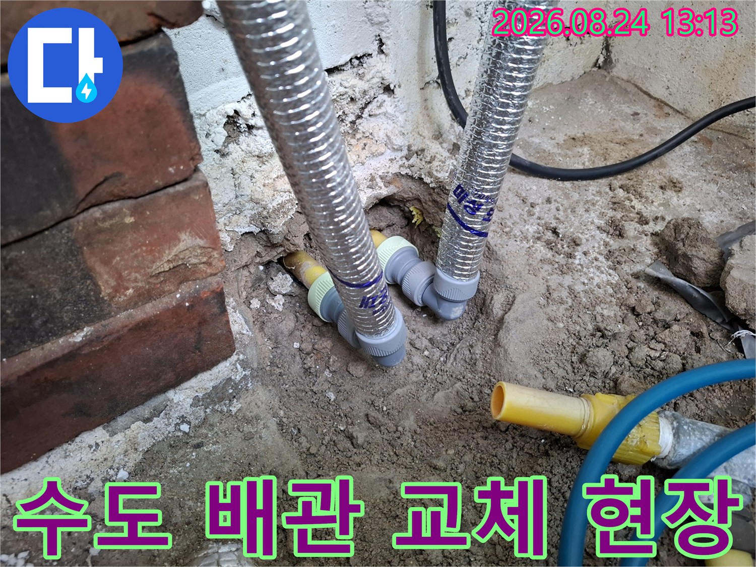 노란색 수도 배관과 은색 자재가 연결된 굴착 부위의 상세 모습입니다.