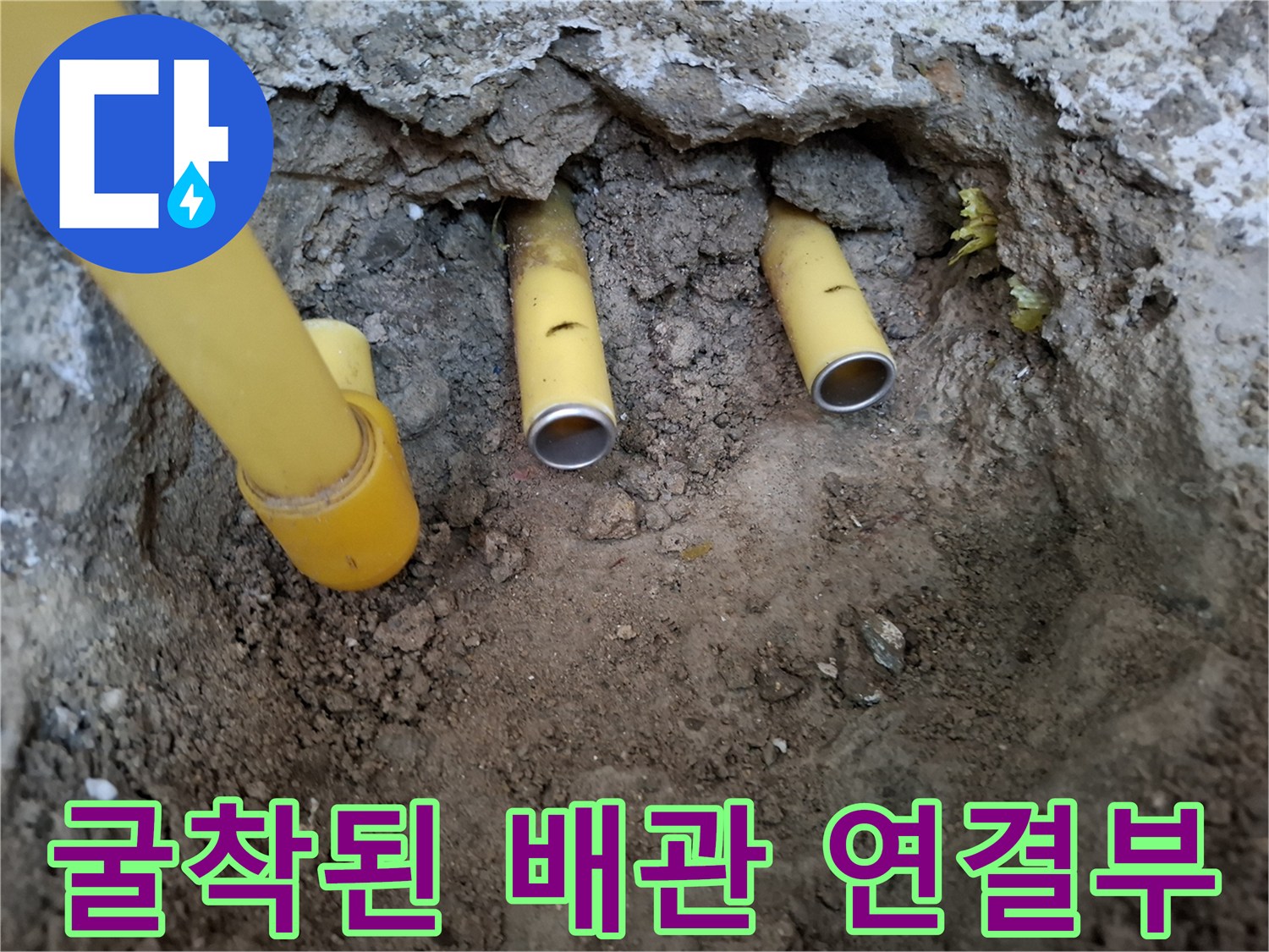 바닥 흙을 제거하고 드러난 노란색 수도관의 균열 부위 - 배관 수리 과정