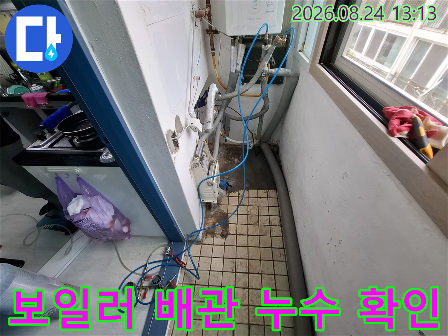 보일러실 벽면 하단의 수도 배관 및 연결 부위 상세 사진