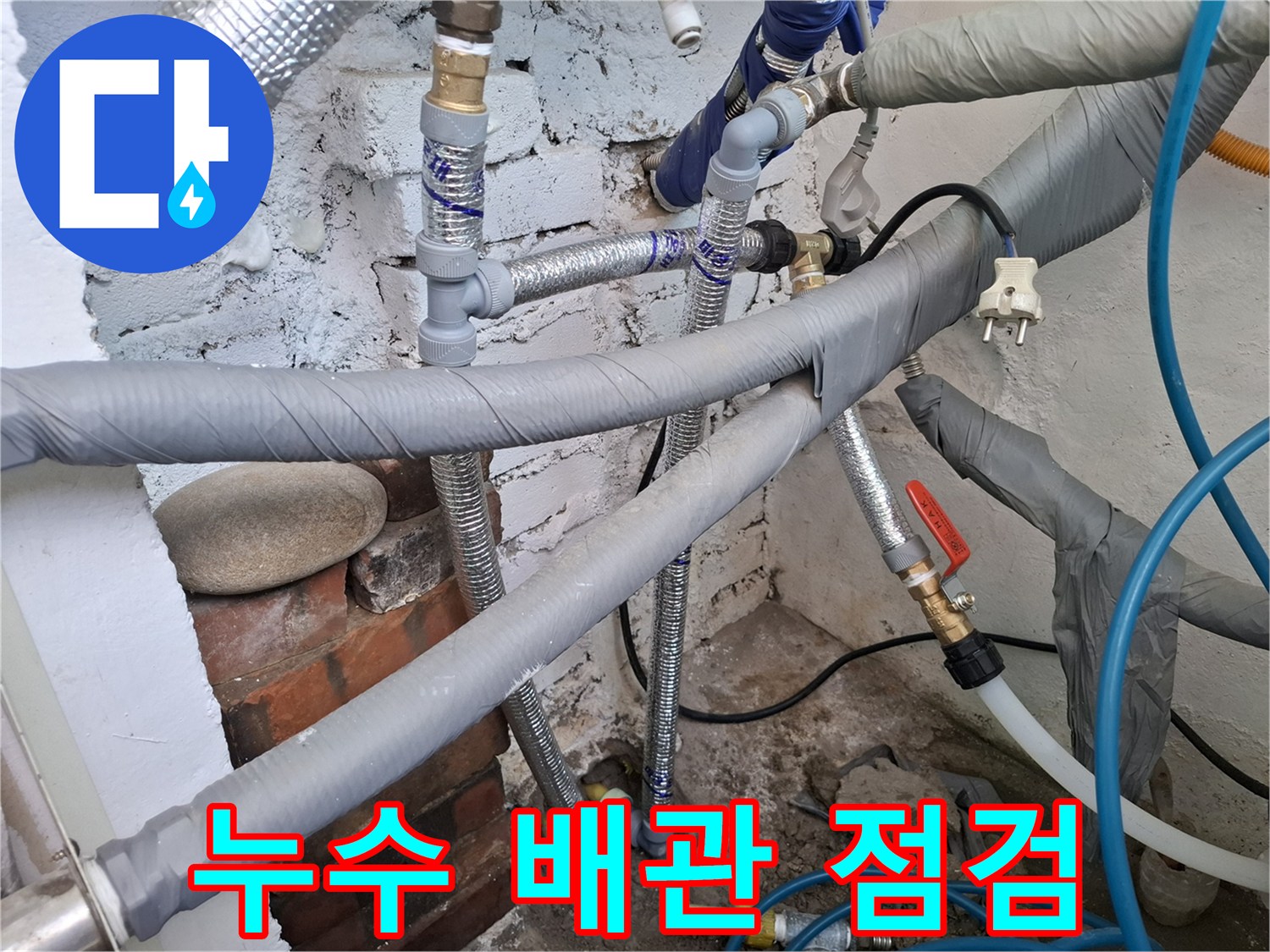 수도배관점검-단열재가 씌워진 은색 배관과 노란색 직수관의 연결부