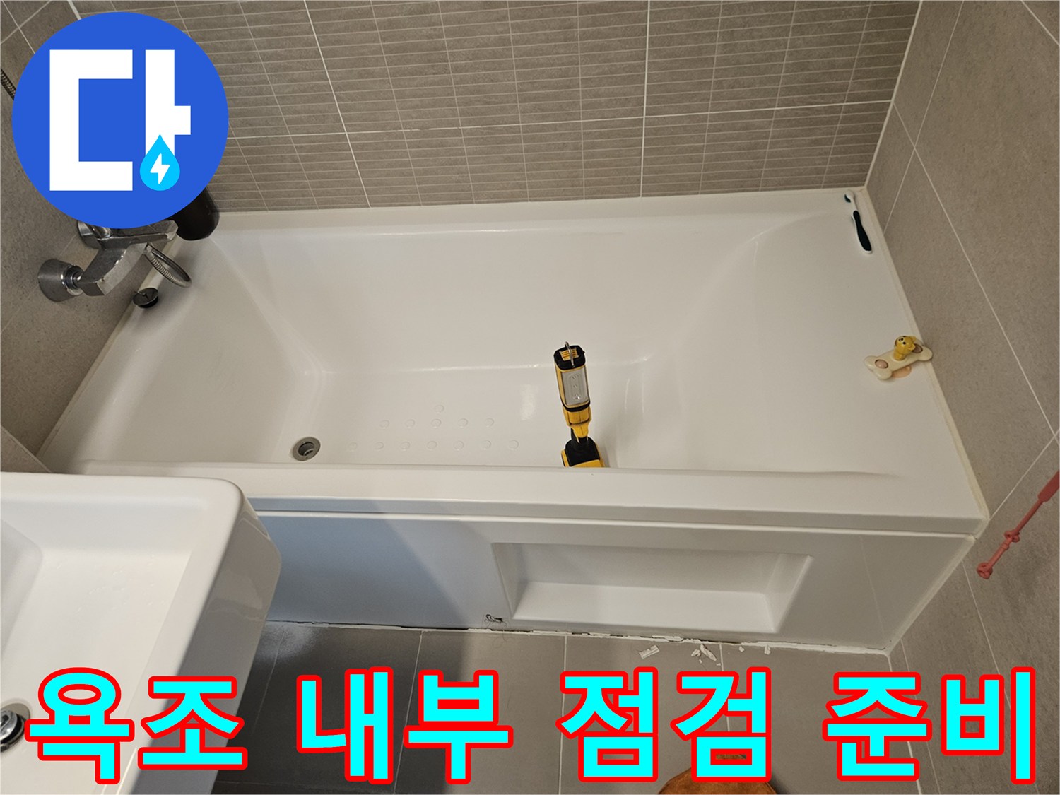 욕조 내부에 놓인 노란색 드릴과 작업용 도구들