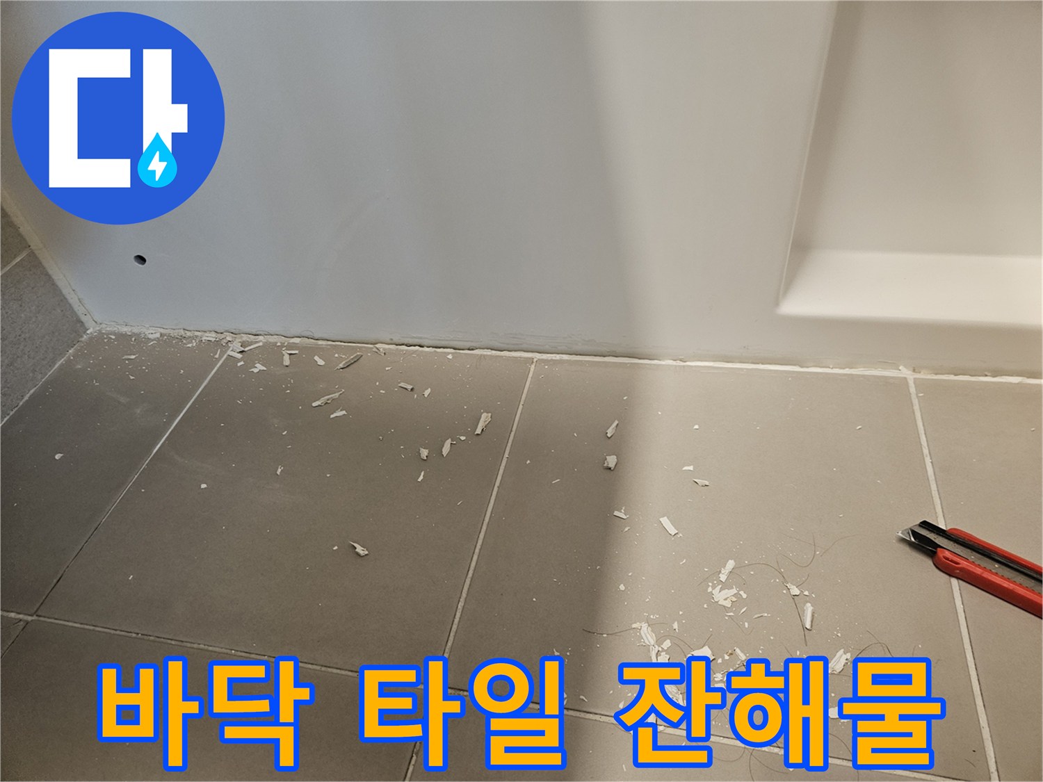 타일 바닥에 떨어진 하얀색 가루와 작은 조각들
