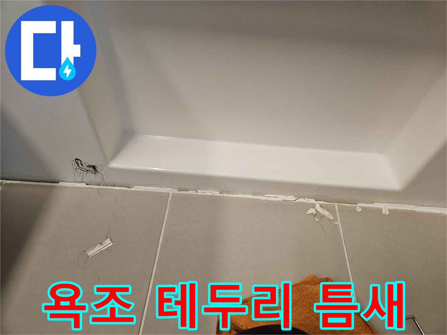 하얀색 욕조와 회색 타일 접합부의 실리콘 파손