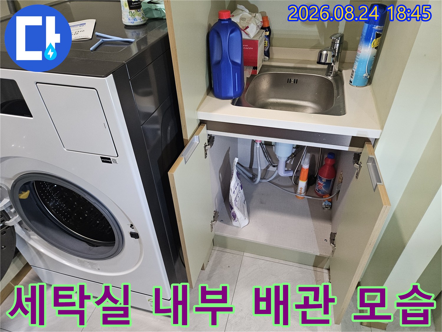 세탁기와 세탁실 하부 선반에 정리된 세정제와 배관의 모습입니다.