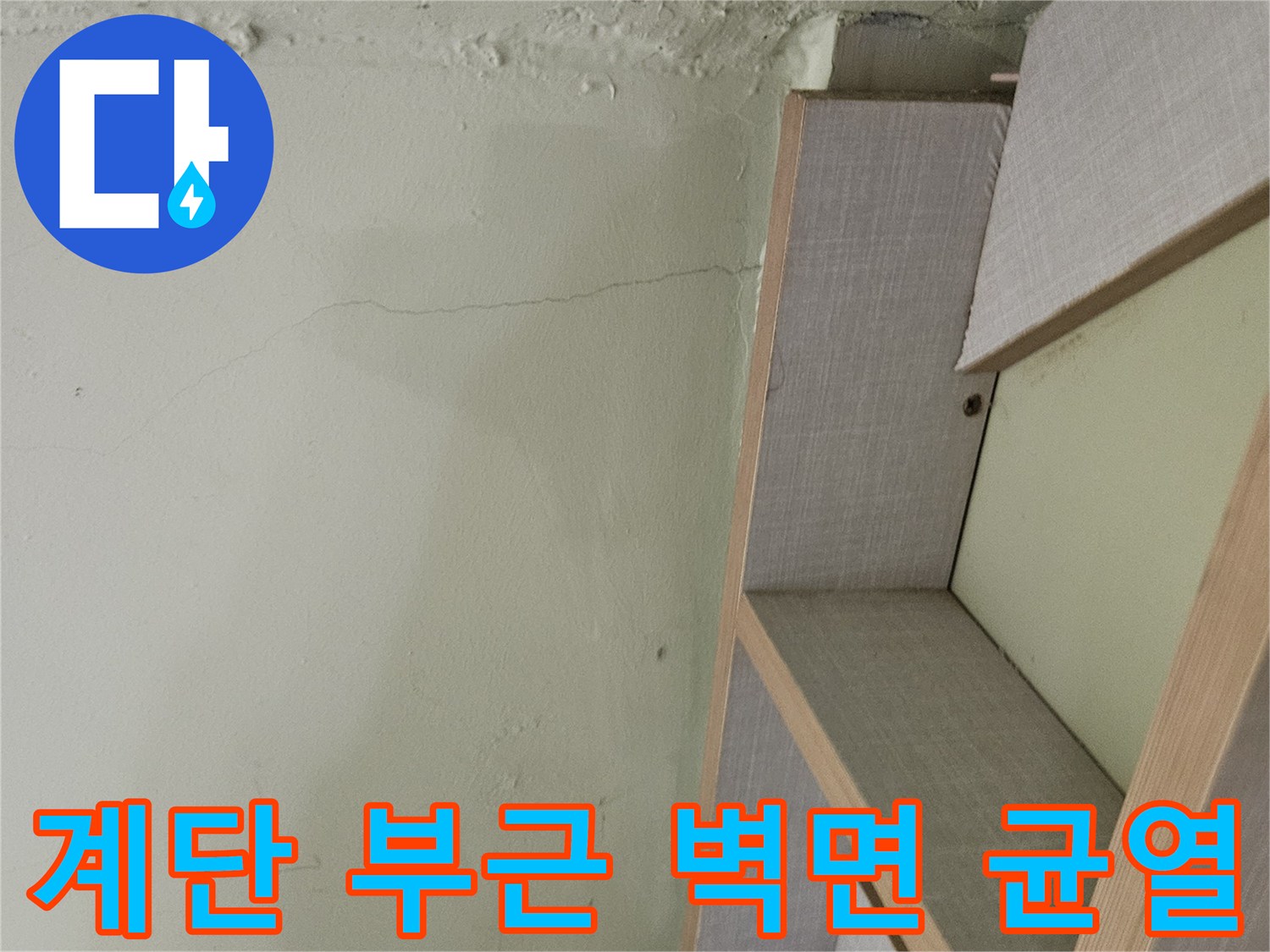 습기가 스며든 것으로 보이는 계단 옆 벽면의 수직 균열 지점