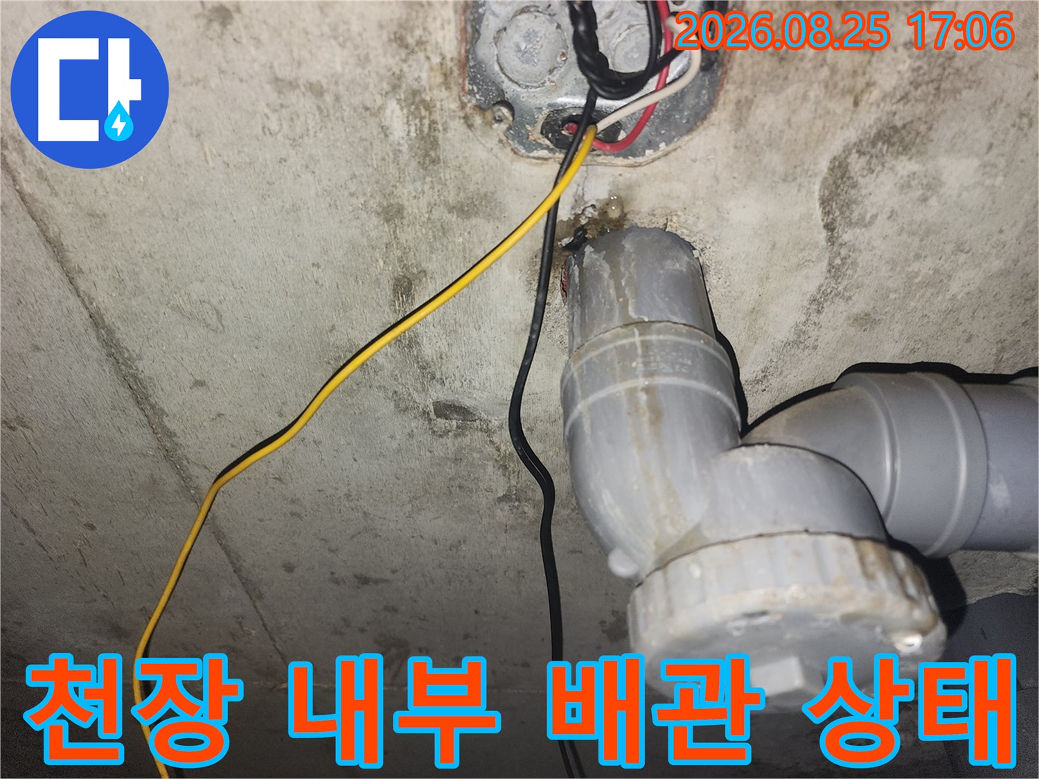 아래층 천장 하수 배관과 전기선이 노출된 현장 사진입니다.