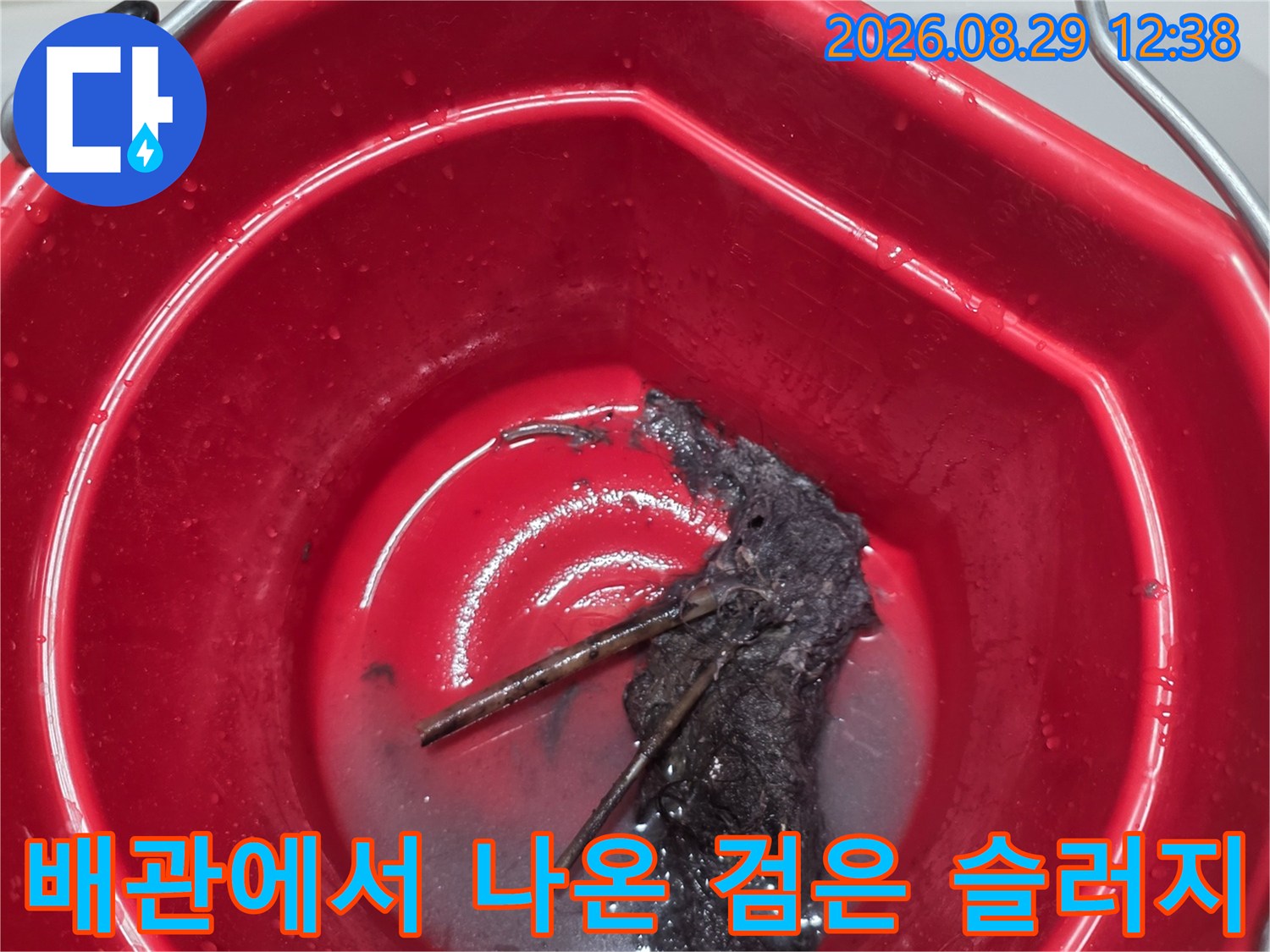 배관 청소 과정에서 수거된 검은색 오물과 이물질 덩어리들